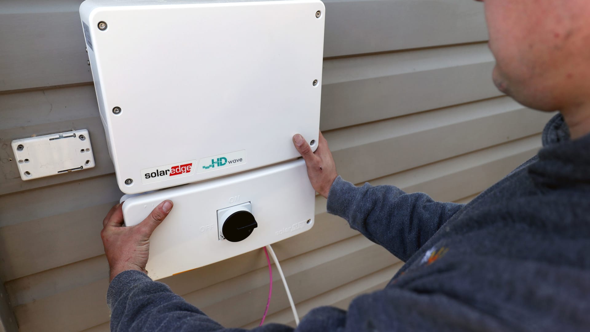 A Solarpro employee installs a SolarEdge Technologies inverter at a residential property in Sydney, Australia, on May 17, 2021.