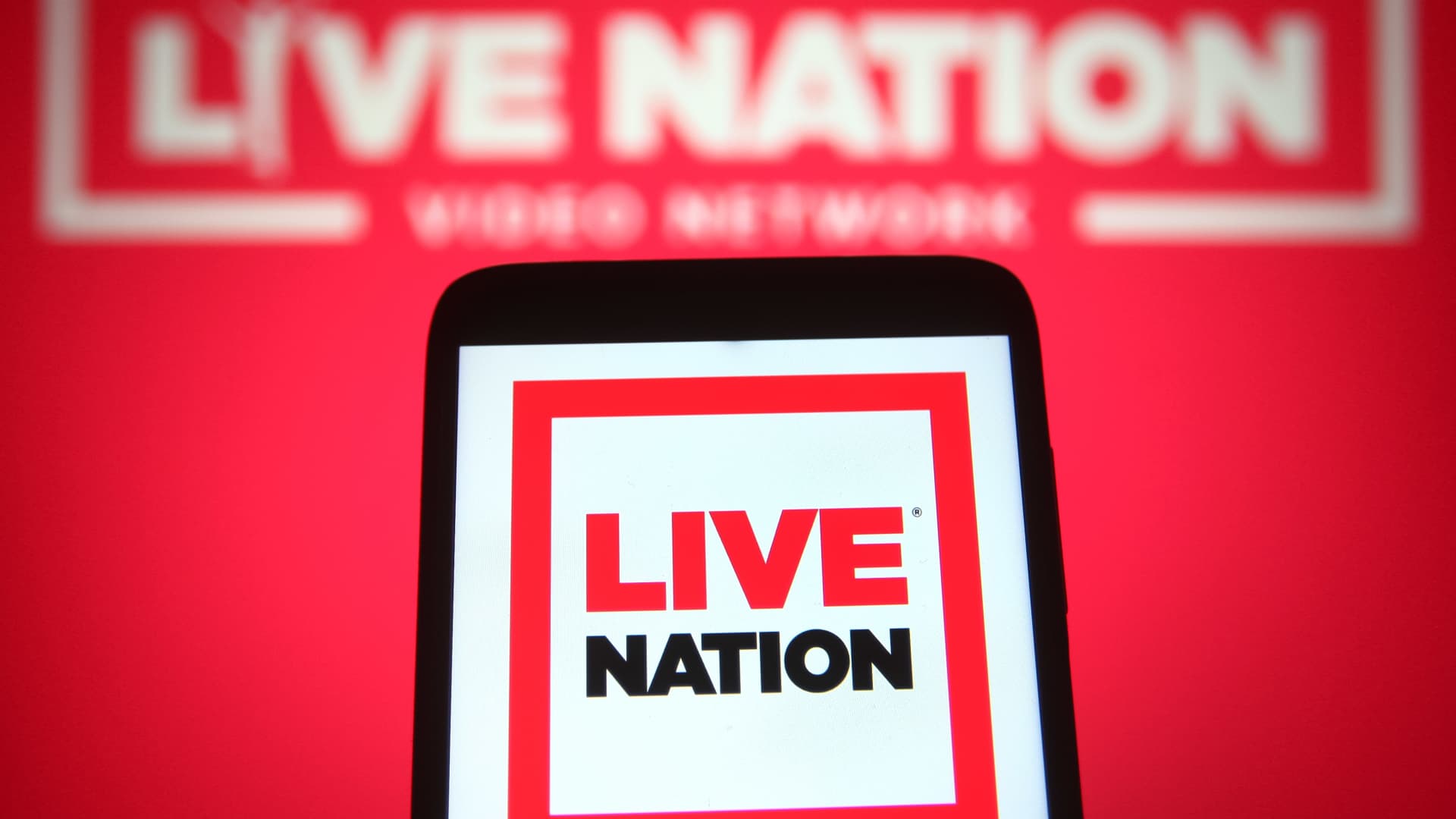 An illustration of a Live Nation Entertainment logo is seen on a smartphone and a pc screen.