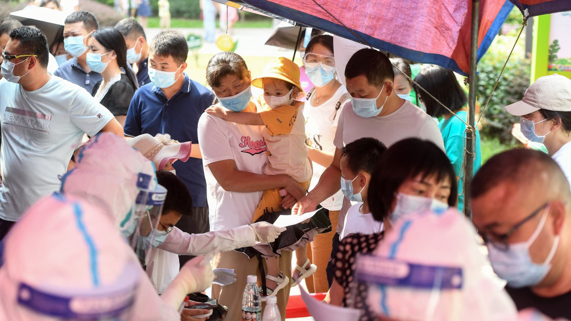 Residents of Wuhan city in China's Hubei province queue to take nucleic acid tests for Covid-19 on August 3, 2021.