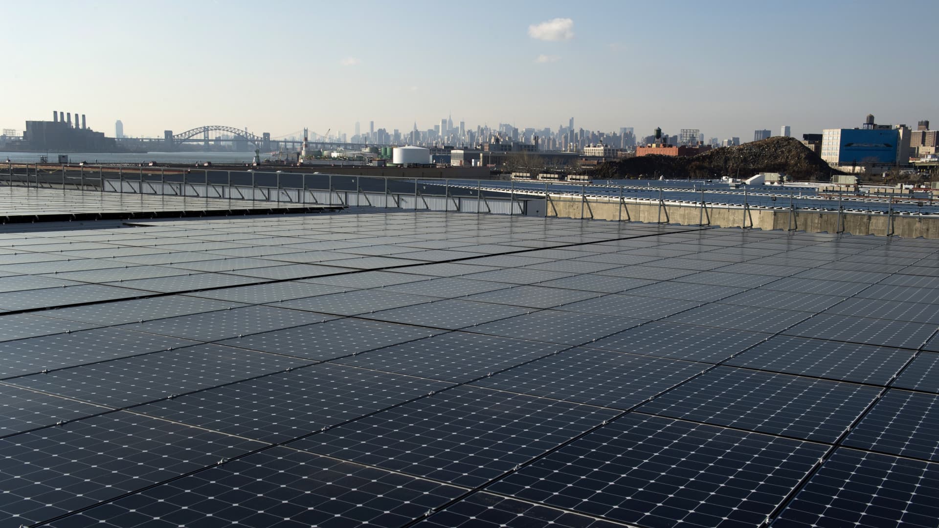 A Bronx rooftop with a view of Manhattan in the distance is covered with solar panels. As climate and racial justice are connected, ESG experts say more clean energy projects and jobs need to come to neglected urban communities.