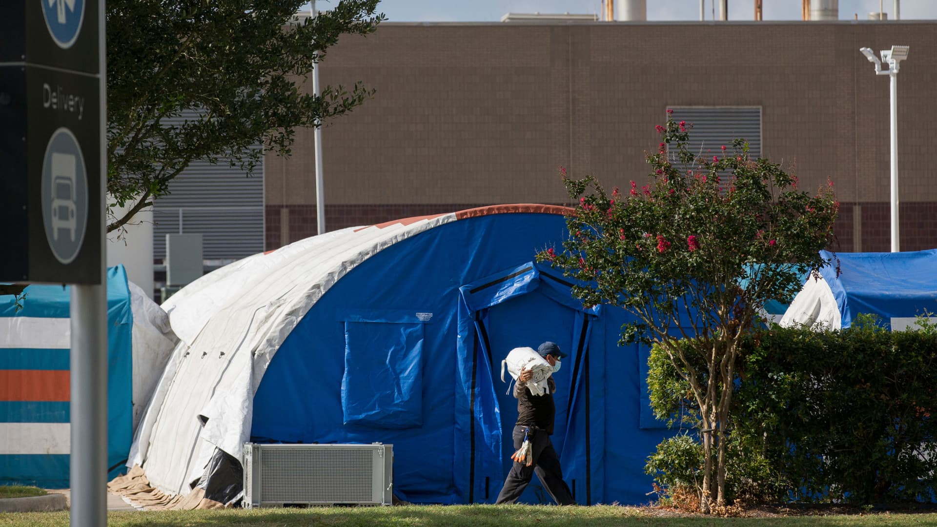 A construction crew works to set up tents that hospital officials plan to use with an overflow of COVID-19 patients outside of Lyndon B. Johnson Hospital, Monday, Aug. 9, 2021, in Houston.