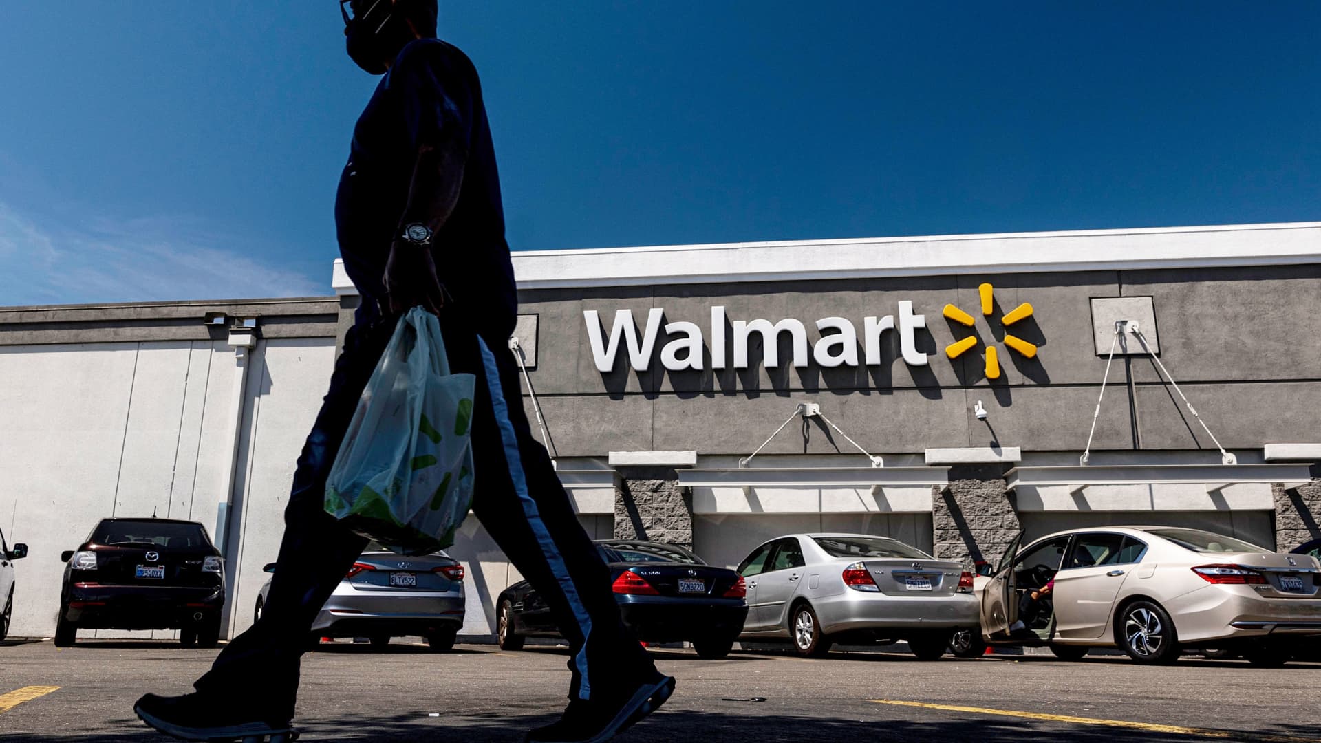 A shopper carries a bag outside a Walmart store in San Leandro, California, on Thursday, May 13, 2021.