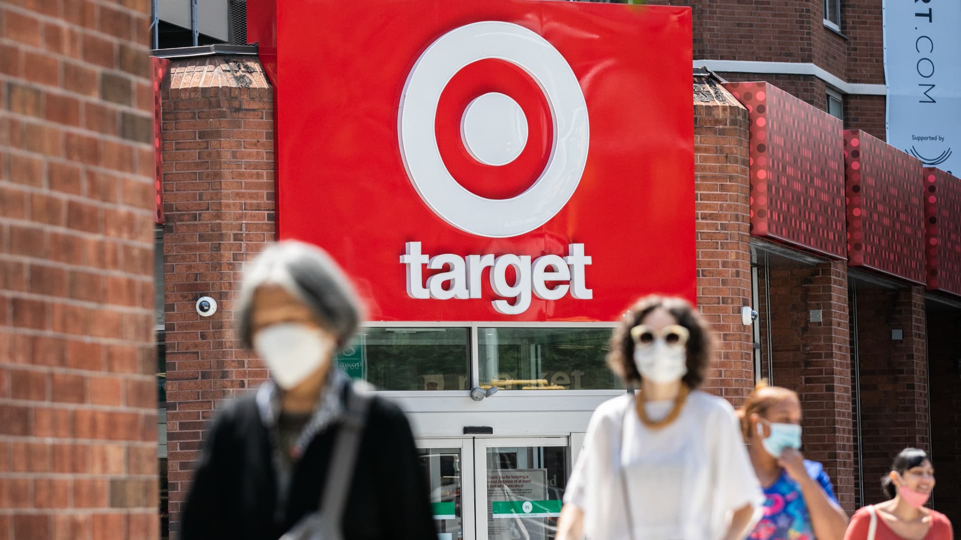 Pedestrians wearing protective masks walk past a Target store in New York, on Monday, Aug. 17, 2020.