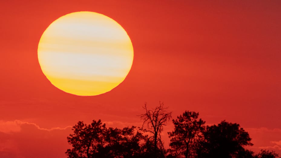 The sun sets behind smoke from a distant wildfire as drought conditions worsen on July 12, 2021 near Glennville, California.
