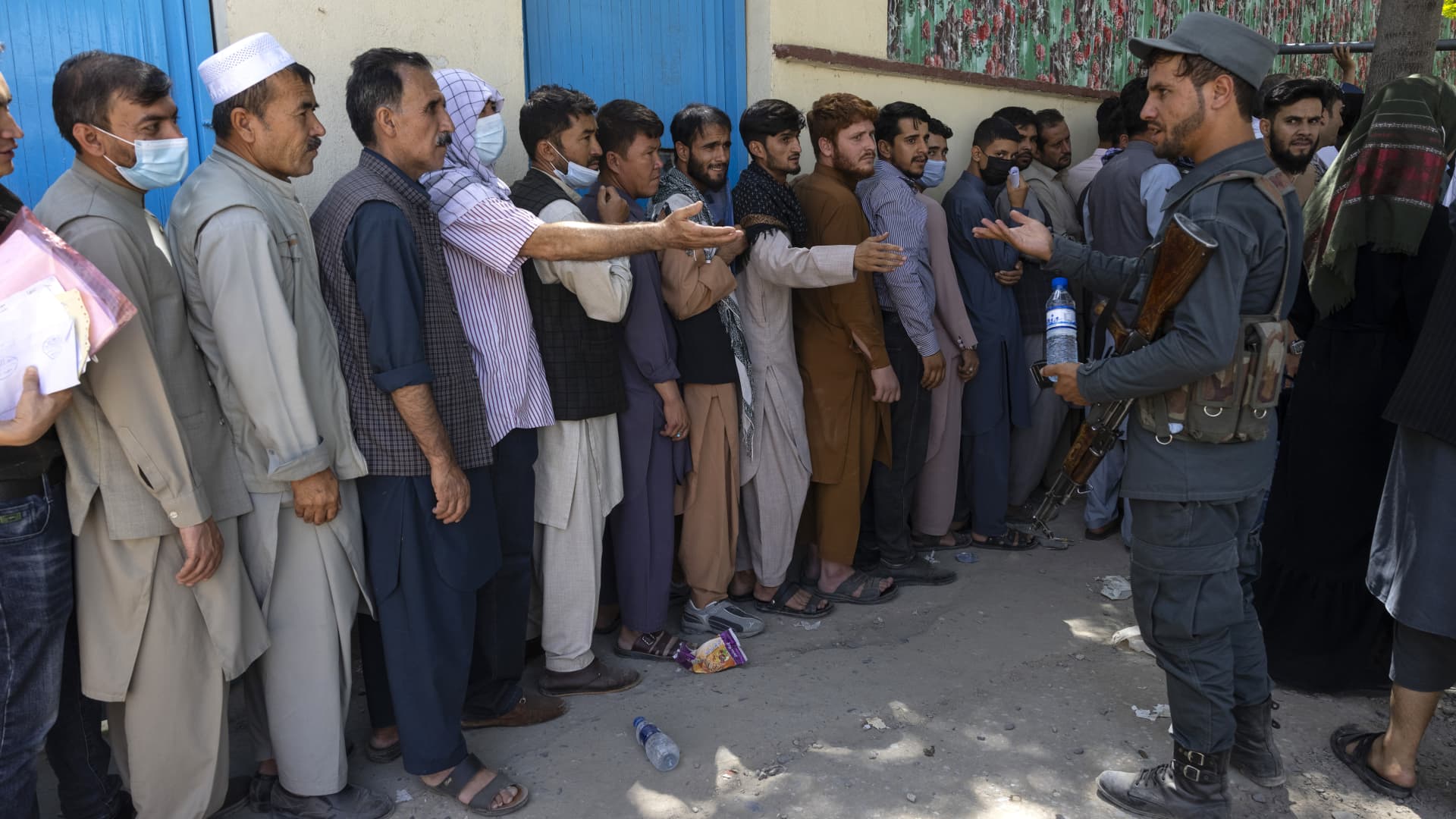 Afghans wait in long lines for hours at the passport office as many are desperate to have their travel documents ready to go on August 14, 2021 in Kabul, Afghanistan.