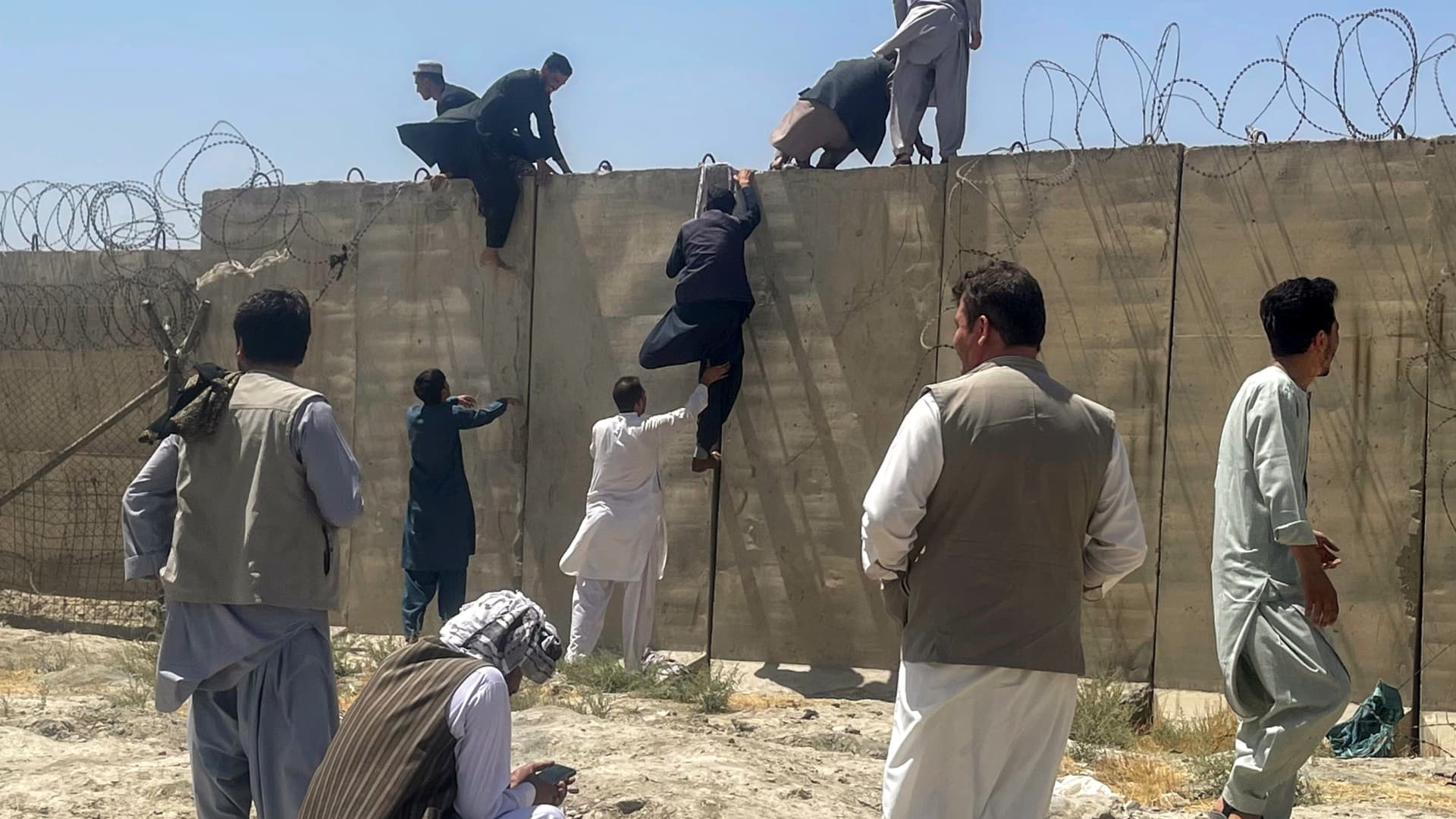 Men try to get inside Hamid Karzai International Airport in Kabul, Afghanistan August 16, 2021.