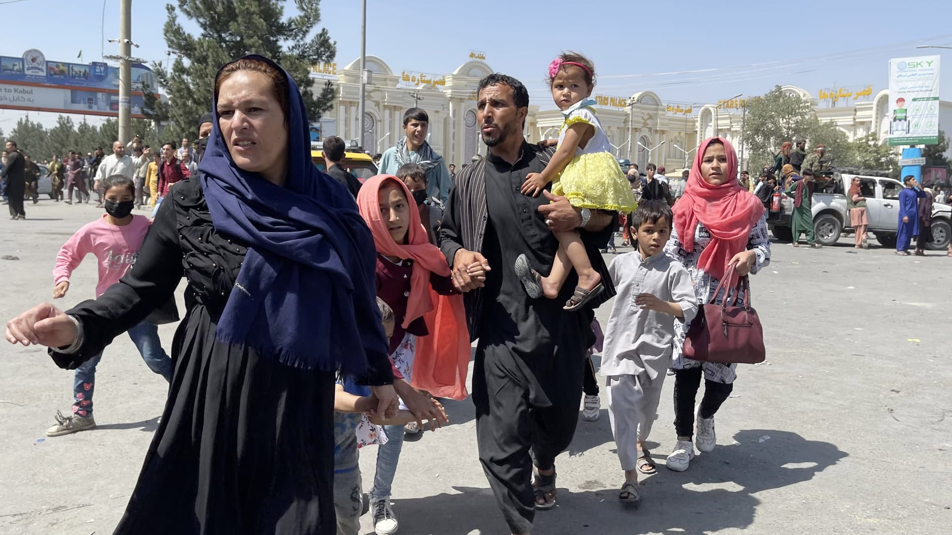 An Afghan family rushes to the Hamid Karzai International Airport as they flee the Afghan capital of Kabul, Afghanistan, on August 16, 2021.