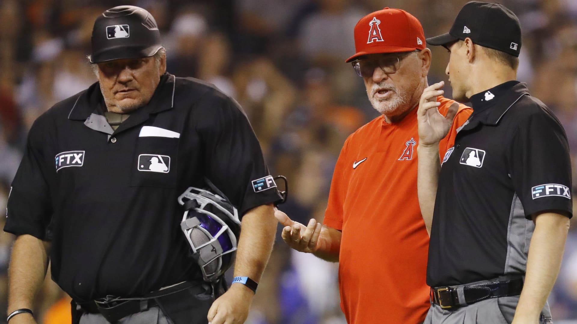 Los Angeles Angels Manager Joe Maddon #70 talks with the umpires about fan interference during the seventh inning of the game against the Detroit Tigers at Comerica Park on August 17, 2021 in Detroit, Michigan.