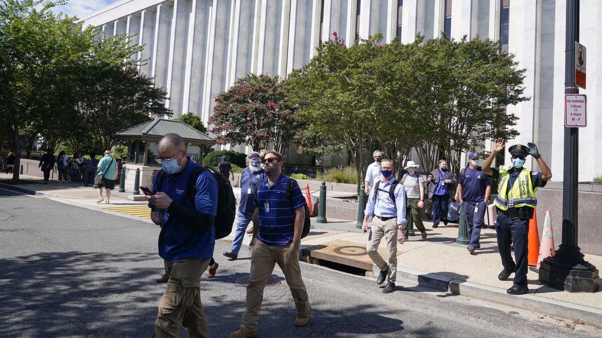 People are evacuated from the James Madison Memorial Building, a Library of Congress building, in Washington on Thursday, Aug. 19, 2021, as law enforcement investigate a report of a pickup truck containing an explosive device near the U.S. Capitol.