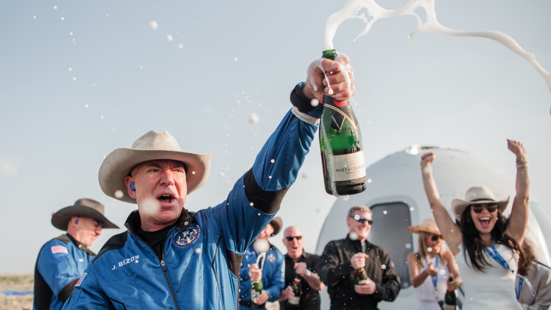 Jeff Bezos pops champagne after emerging from the New Shepard capsule after his spaceflight on July 20, 2021.