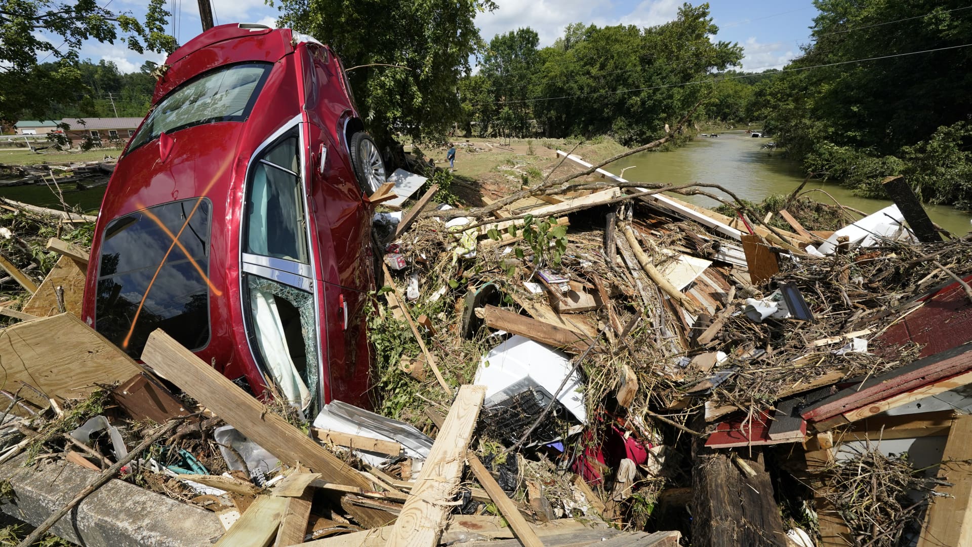 A car is among debris that washed up against a bridge over a stream Sunday, Aug. 22, 2021, in Waverly, Tenn.