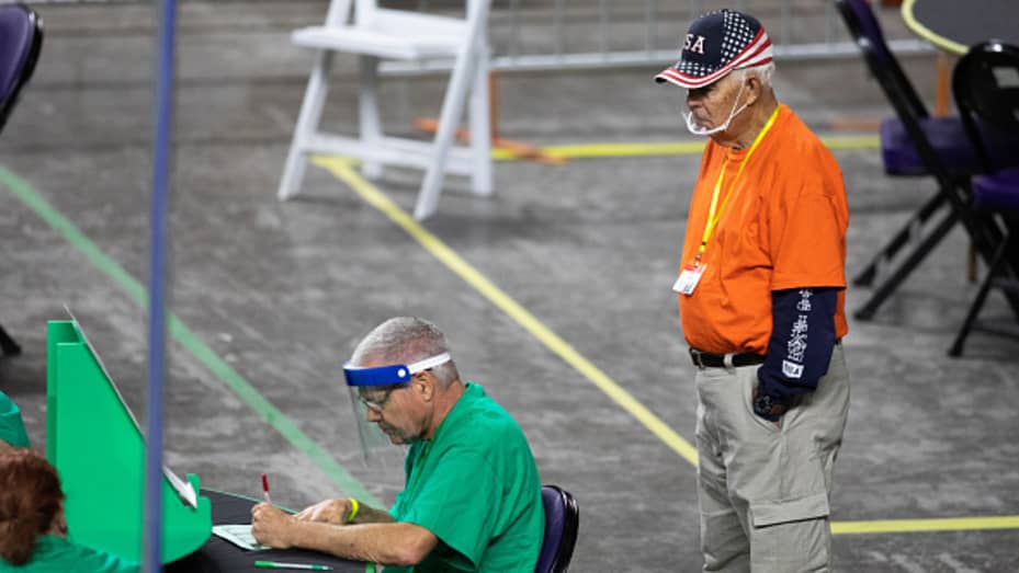 An observer watches as contractors working for Cyber Ninjas, who was hired by the Arizona State Senate, examine and recount ballots from the 2020 general election at Veterans Memorial Coliseum on May 8, 2021 in Phoenix, Arizona.