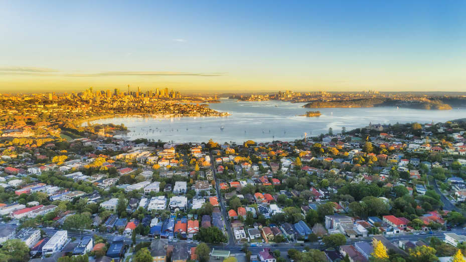 Eastern suburbs of Sydney city around Harbour in aerial view with soft morning light and blue sky.