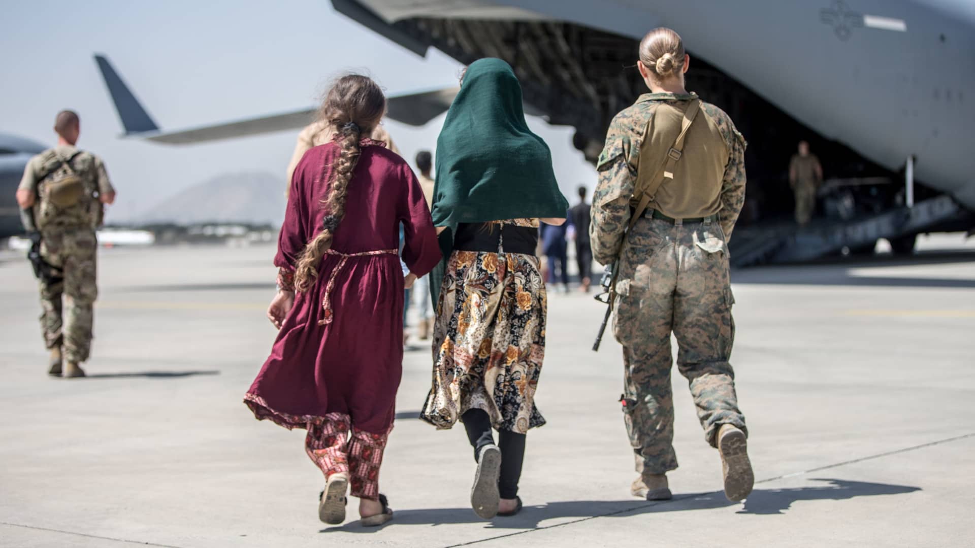 A Marine with the 24th Marine Expeditionary Unit walks with the children during an evacuation at Hamid Karzai International Airport in Kabul, Afghanistan, August 24, 2021.