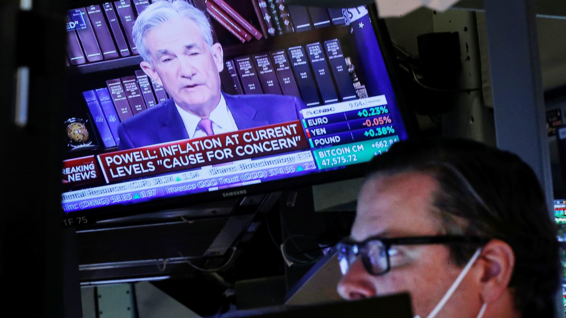 A screen shows Federal Reserve Chair Jerome Powell speak as a trader works inside a post on the floor of the New York Stock Exchange (NYSE), August 27, 2021.