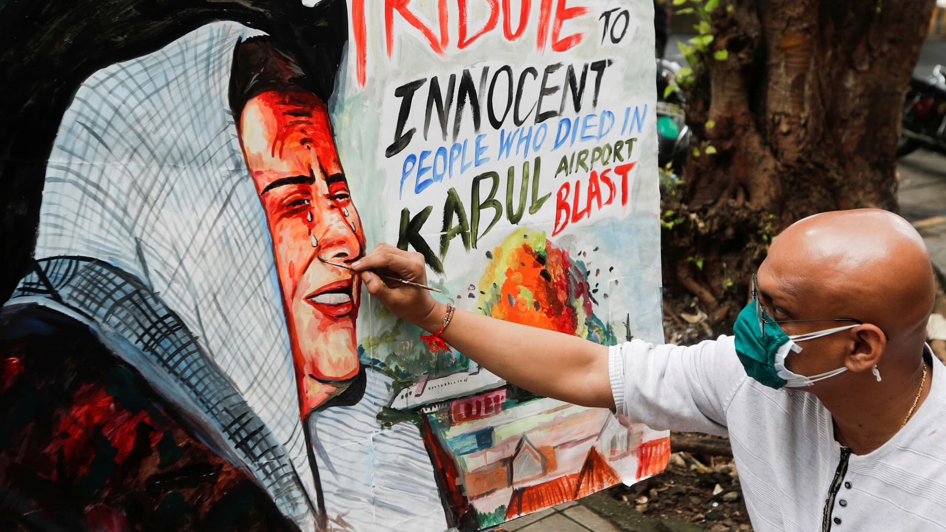 An artist paints a tribute to victims of the bomb blasts at the Hamid Kazrai International airport in Kabul, outside an art school in Mumbai, India, August 27, 2021.