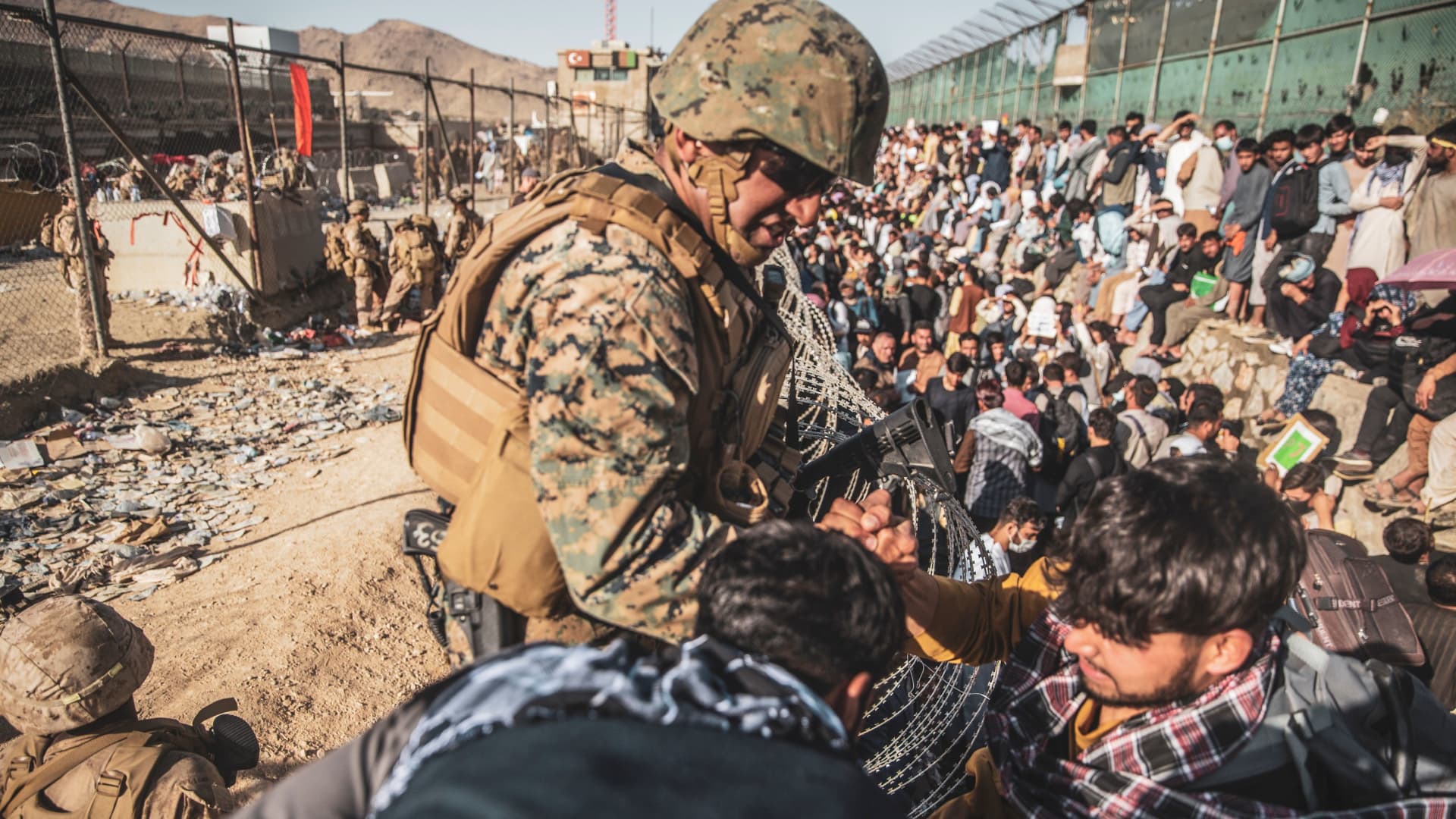 A U.S. Marine assists at an Evacuation Control Check Point (ECC) during an evacuation at Hamid Karzai International Airport, Kabul, Afghanistan, August 26, 2021.