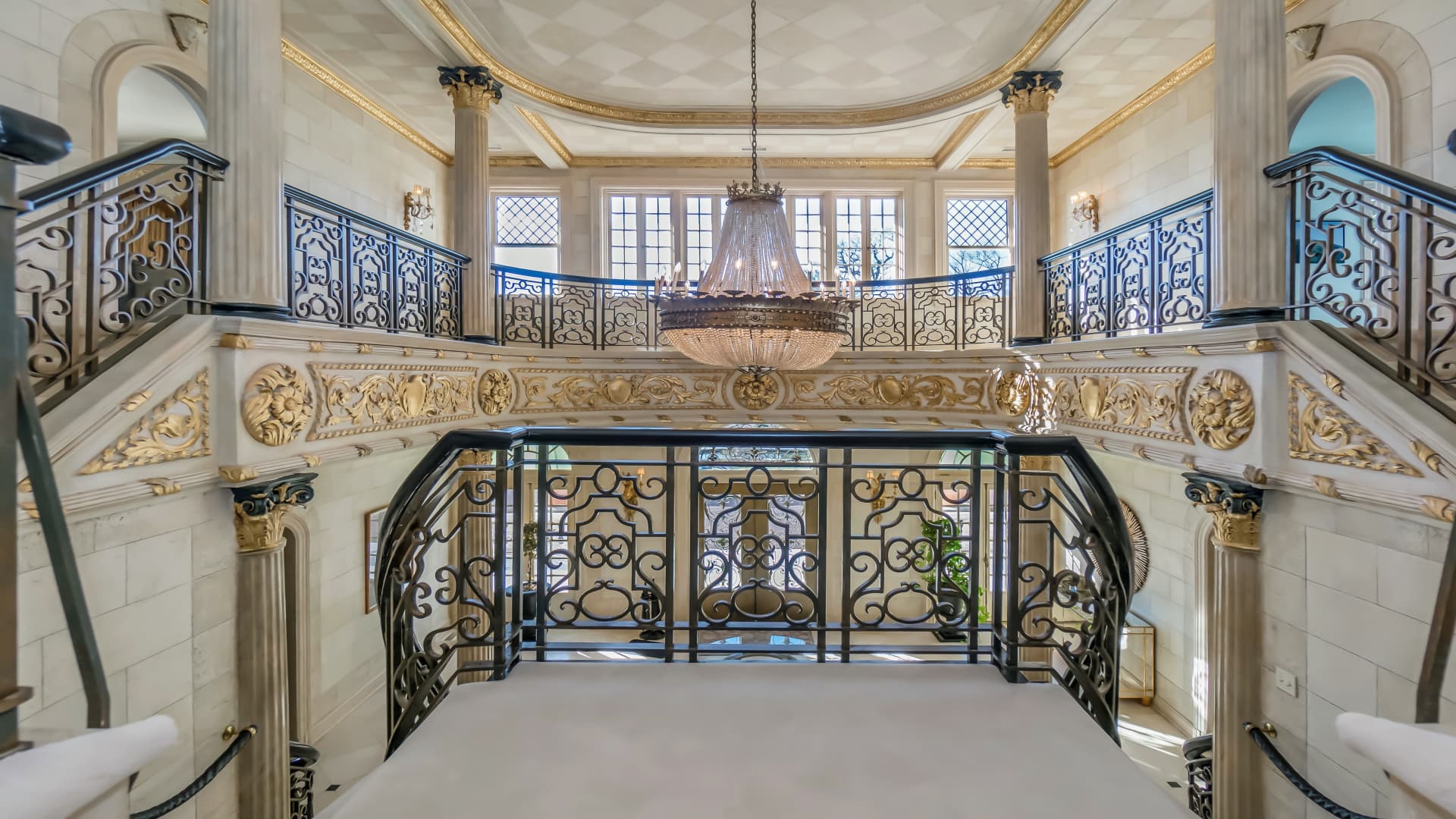 The grand entryway includes ornate trim and double height ceilings.