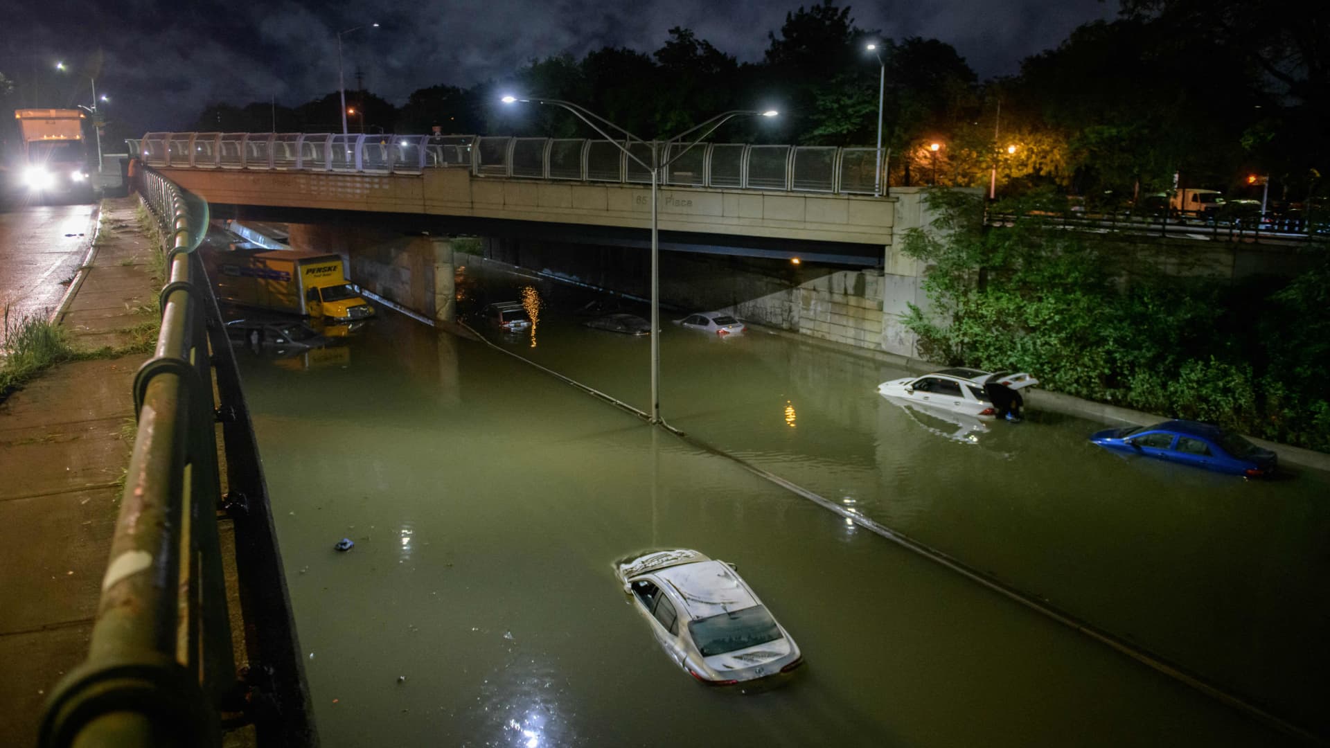 Floodwater surrounds vehicles following heavy rain on an expressway in Brooklyn, New York.