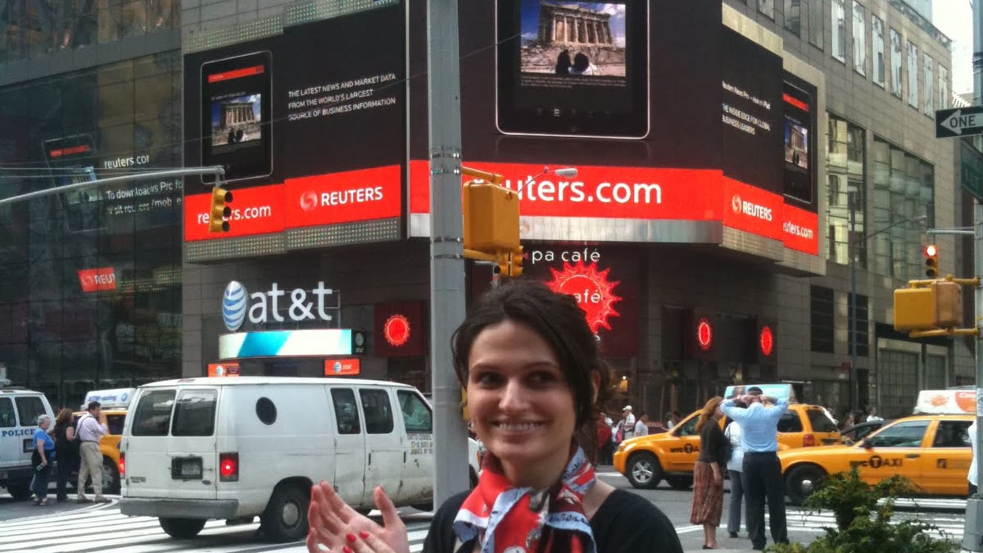 Alina Vandenberghe in New York City's Times Square, standing below an ad for the Thomas Reuters iPad app she designed.