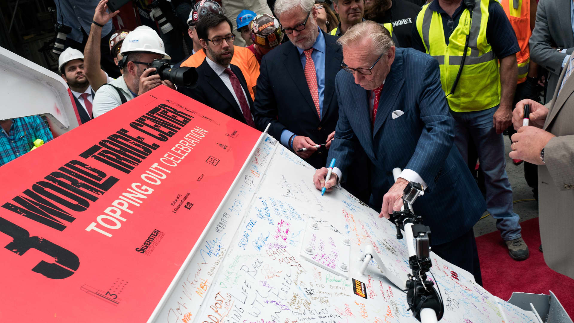 Real estate developer Larry Silverstein signs a concrete bucket before it is lifted to the top of the building during a topping off ceremony for 3 World Trade Center, June 23, 2016 in New York City. The ceremony marks the completion of the 2.5 billion dollar building's concrete core. 3 World Trade Center will stand 1,079-foot tall.