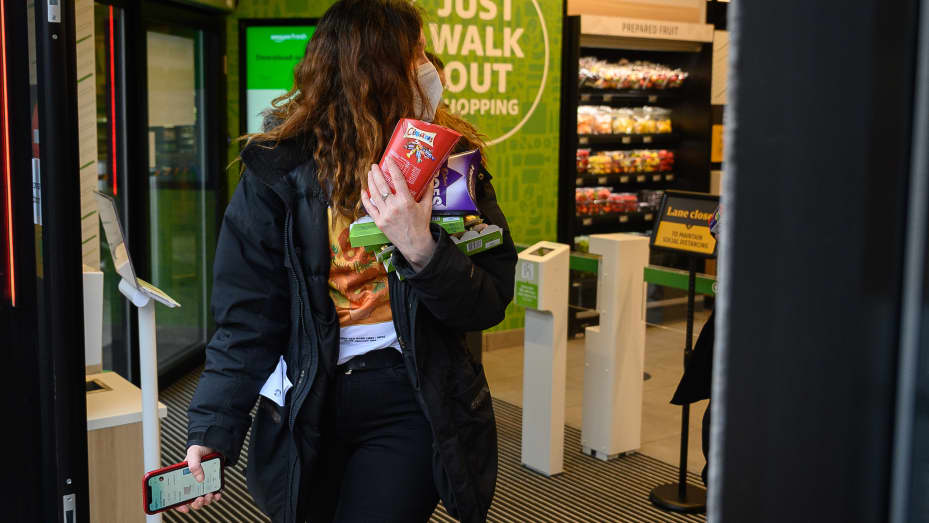 Customers carry their purchases as they leave the UK's first branch of Amazon Fresh, on March 04, 2021, in the Ealing area of London, England.
