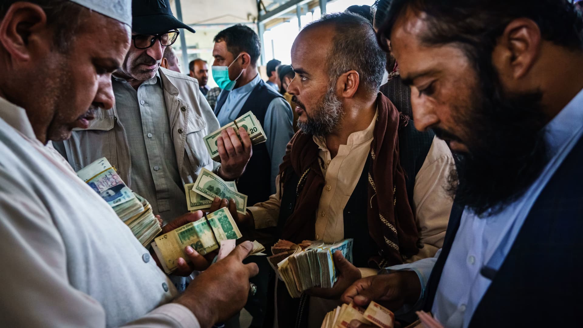Money exchangers engage in intense negotiations in the Sarai Shahzadah, Kabul's currency exchange market, which is reopening for the first time since the Taliban took over, in Kabul, Afghanistan, Saturday, Sept. 4, 2021.