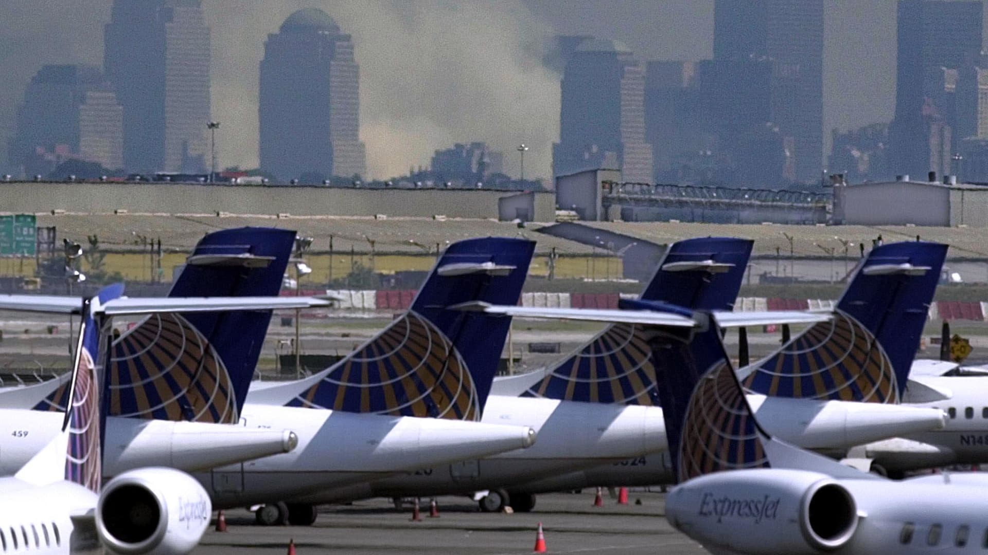 Smoke continues to billow from the remains of the World Trade Center as Continental Express planes sit at the closed Newark, New Jersey Airport 12 September 2001 in the wake of the terrorist attack on the World Trade Center. One of the hijacked planes departed the Newark Airport and later crashed near Pittsburgh, Pennsylvania.
