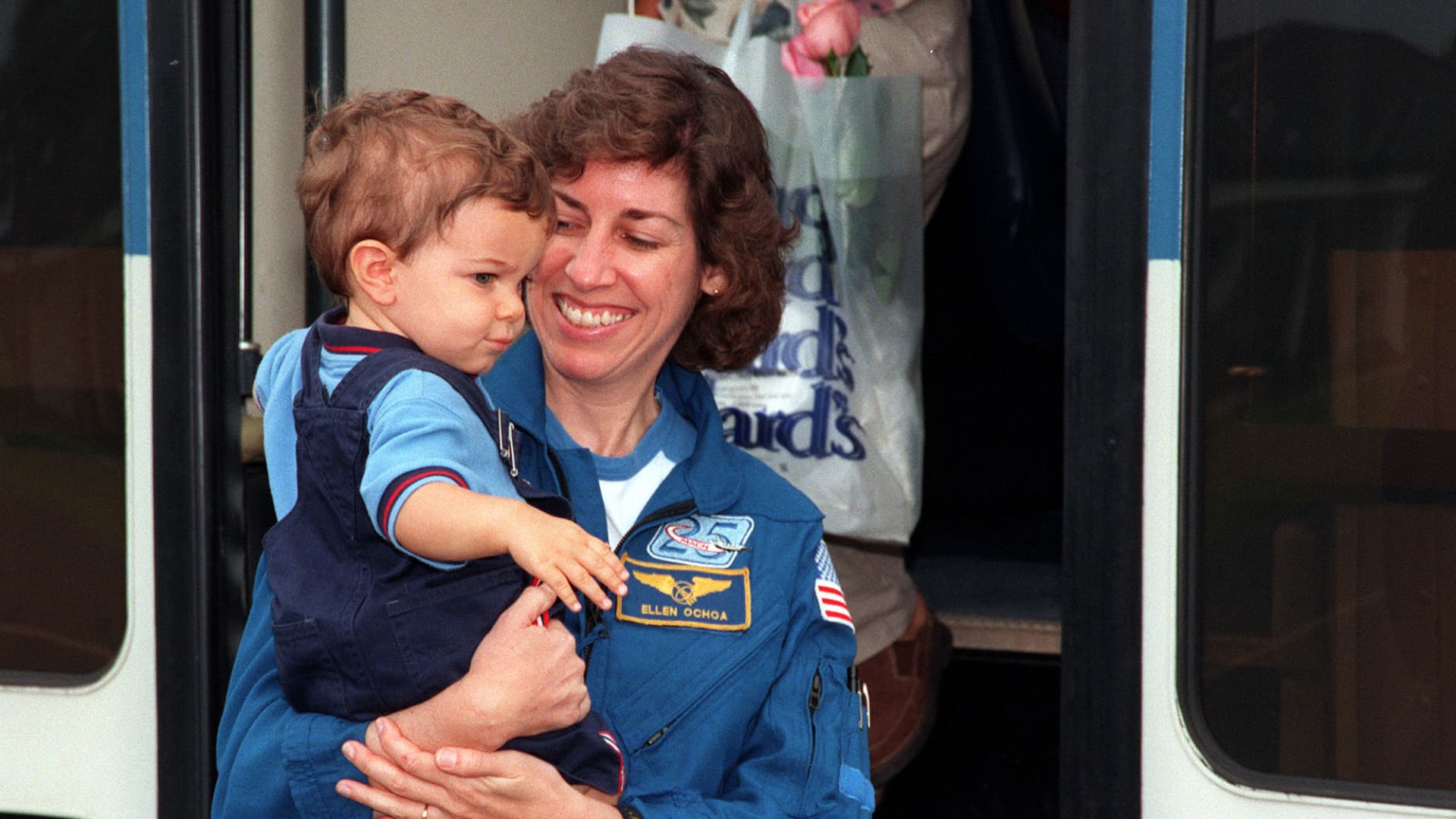 STS-96 Mission Specialist Ellen Ochoa holds her son, Wilson Miles-Ochoa as she steps off the bus at the Cape Canaveral Air Station Skid Strip June 7, 1999. The STS-96 crew members are preparing to return to the Johnson Space Center in Houston, Texas, after a successful 10-day mission to the International Space Station aboard Space Shuttle Discovery. (photo by NASA)