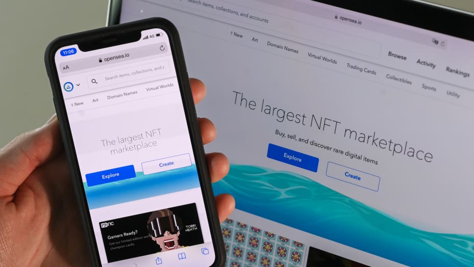 A smartphone and a screen show the website OpenSea, where digital artworks are sold using NFT. NFTs, non-fungible tokens, are unique cryptographic credentials that are written to the blockchain attached to a file (image, music, video).