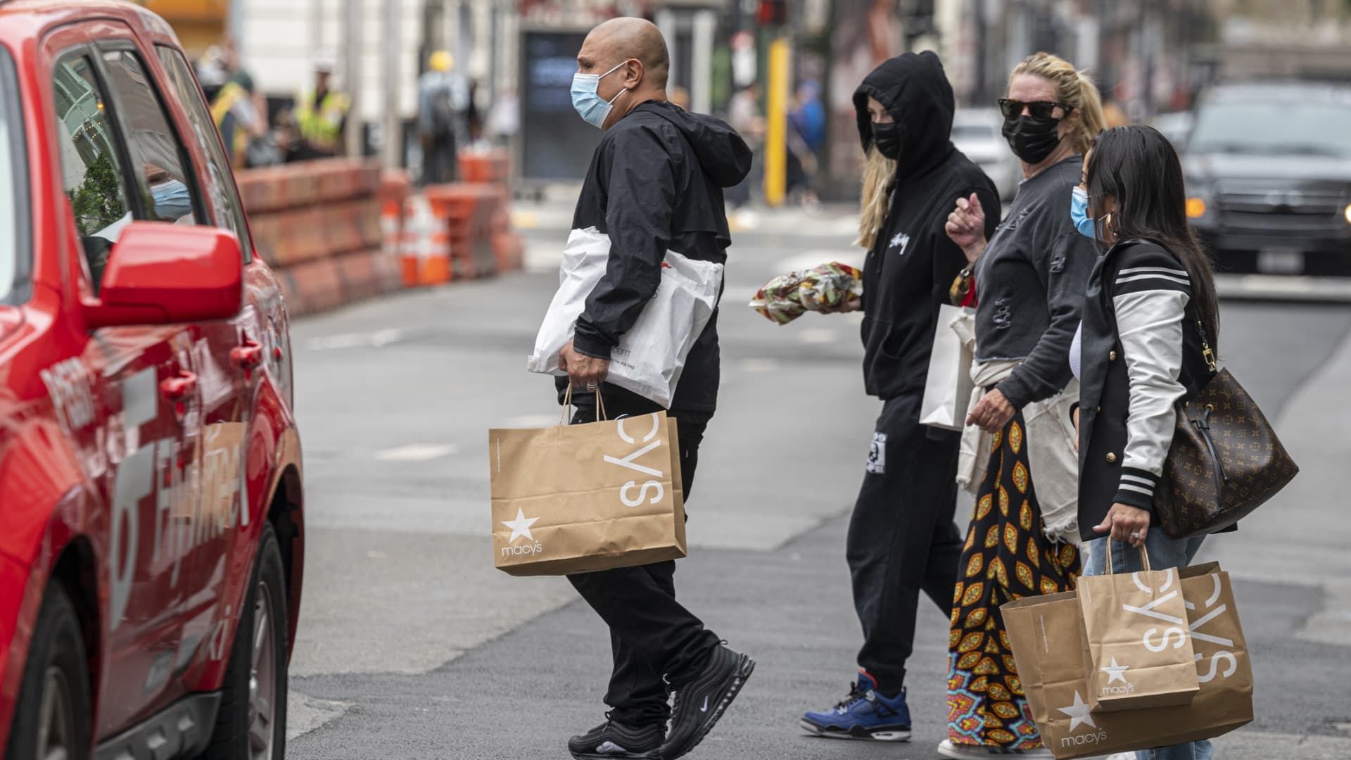 Pedestrians carry Macy's shopping bags in San Francisco, California, U.S., on Thursday, Sept. 16, 2021.