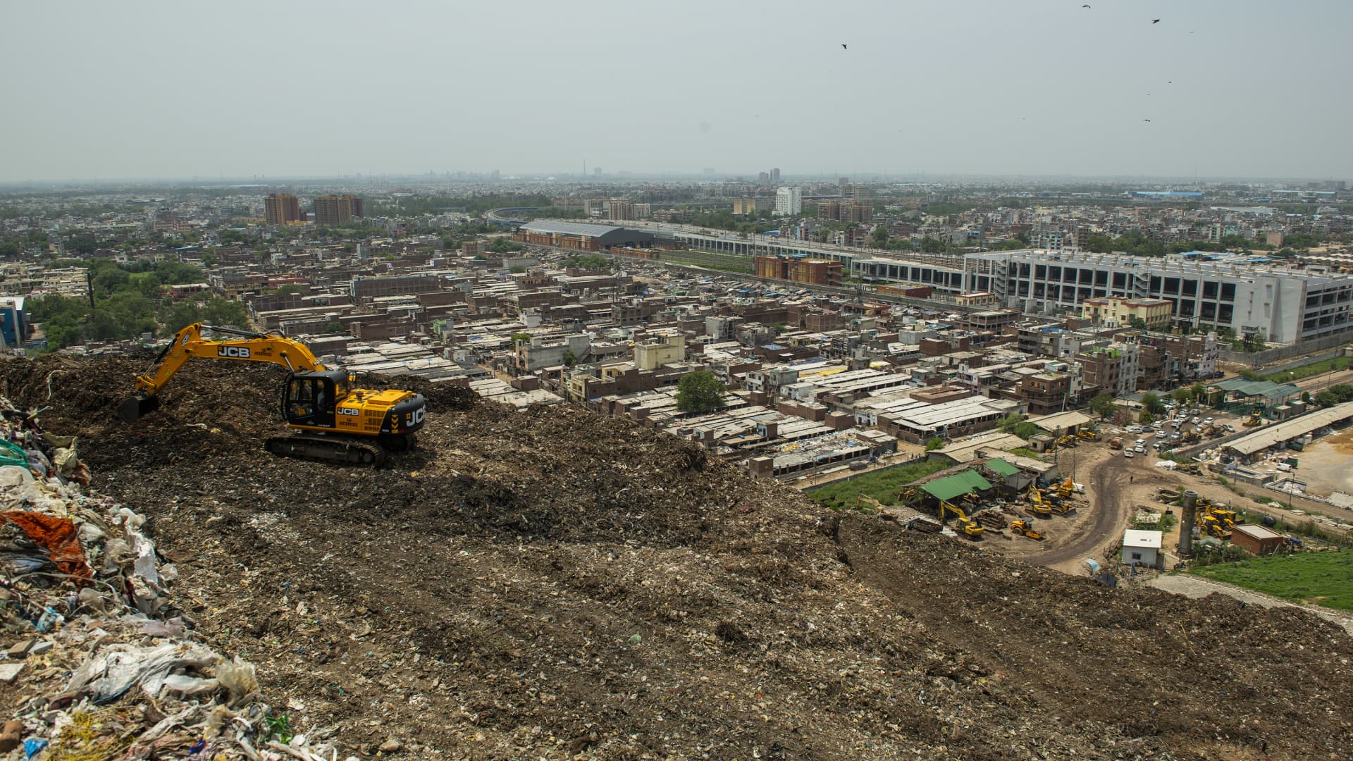 A machine picking up waste in the pile of garbage at the Ghazipur land fill site where city's daily waste has been dumped for last 35 years. The machine separates waste into three parts first stone and heavy concrete material second plastic, polythene and third is fertilizer and soils.