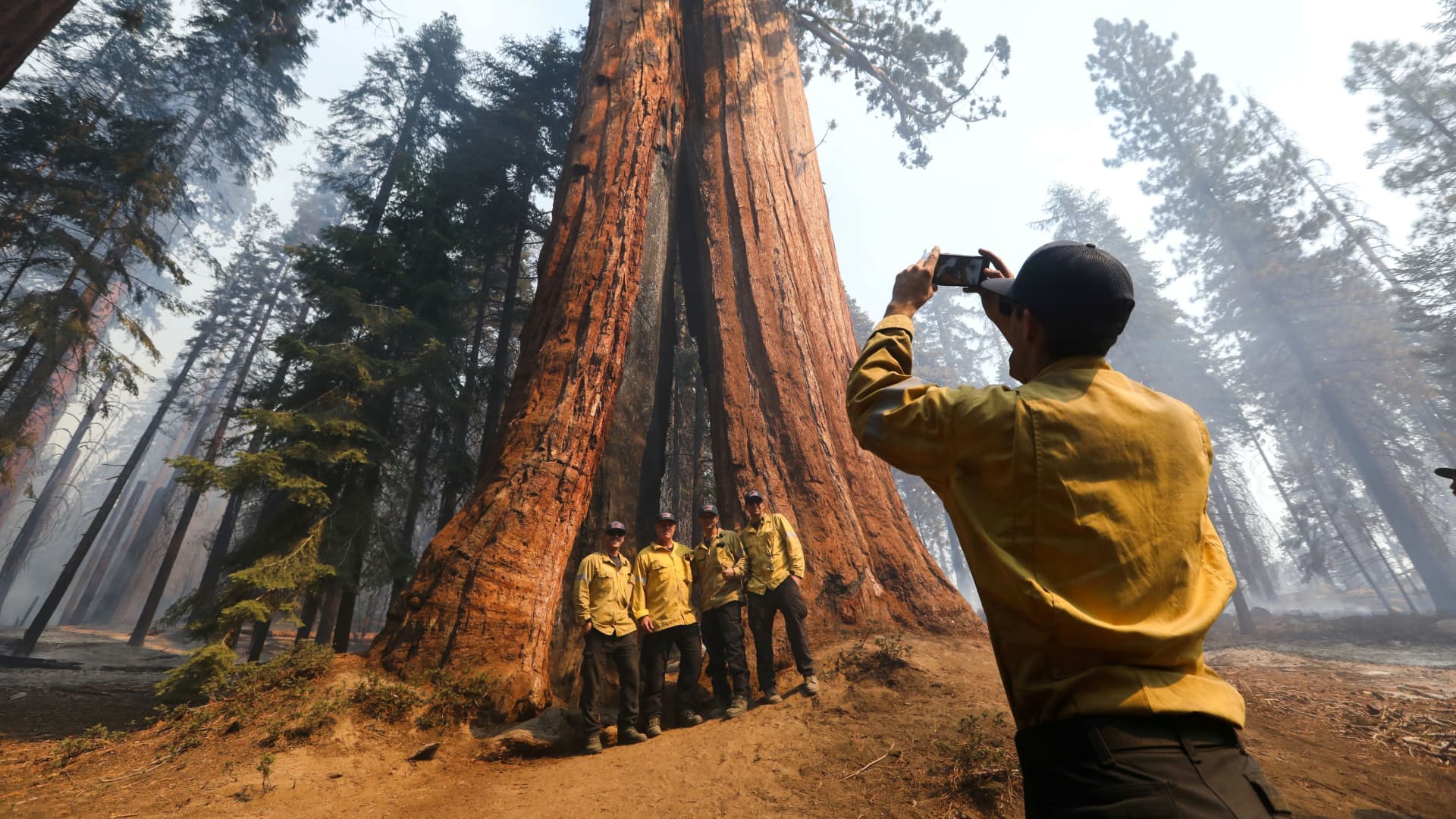 Firefighters from Orange County take photos as the Windy Fire burns in Sequoia National Forest near California Hot Springs, California, Sept. 21, 2021.
