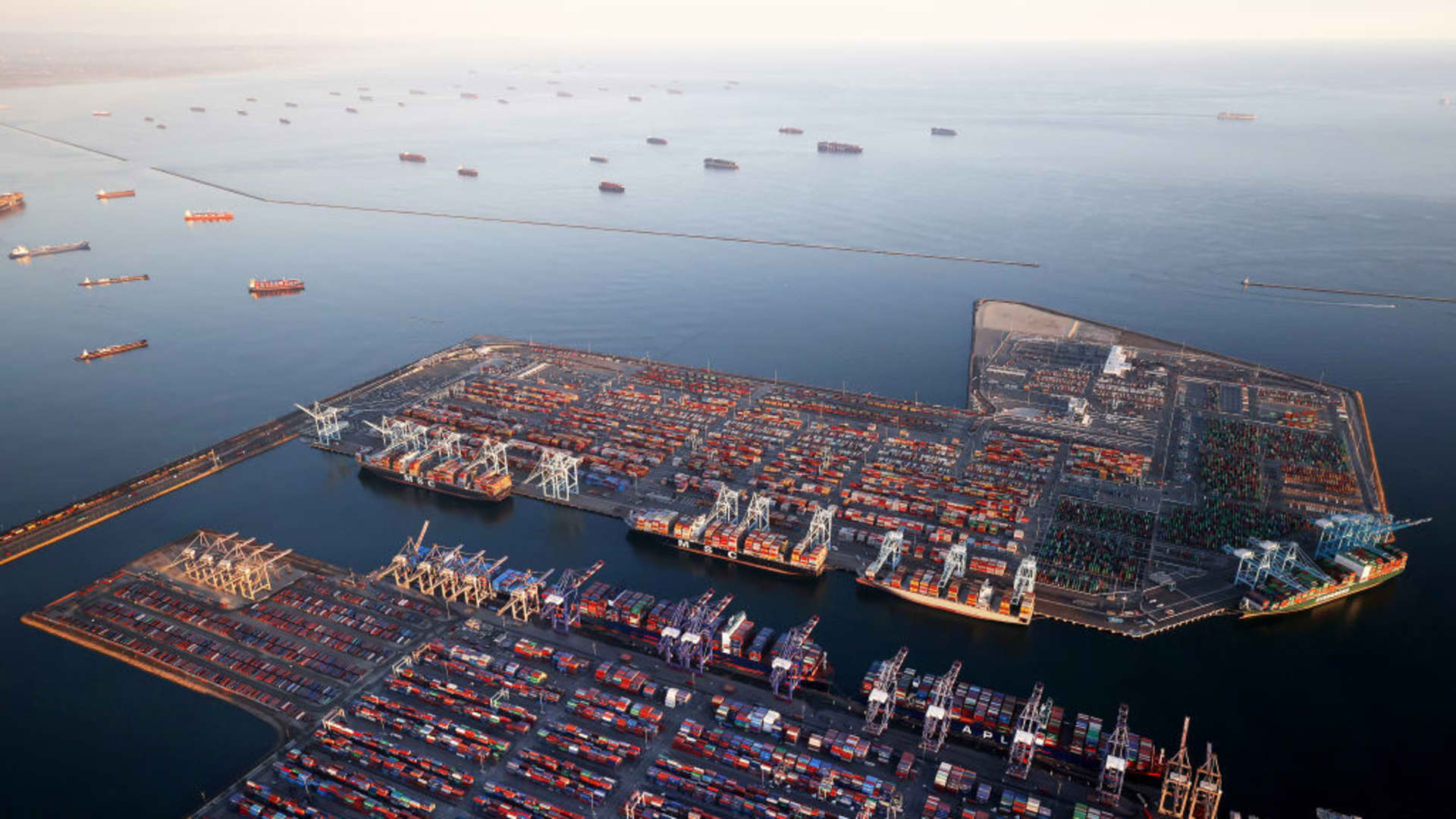 In an aerial view, container ships (Top L) are anchored by the ports of Long Beach and Los Angeles as they wait to offload on September 20, 2021 near Los Angeles, California.
