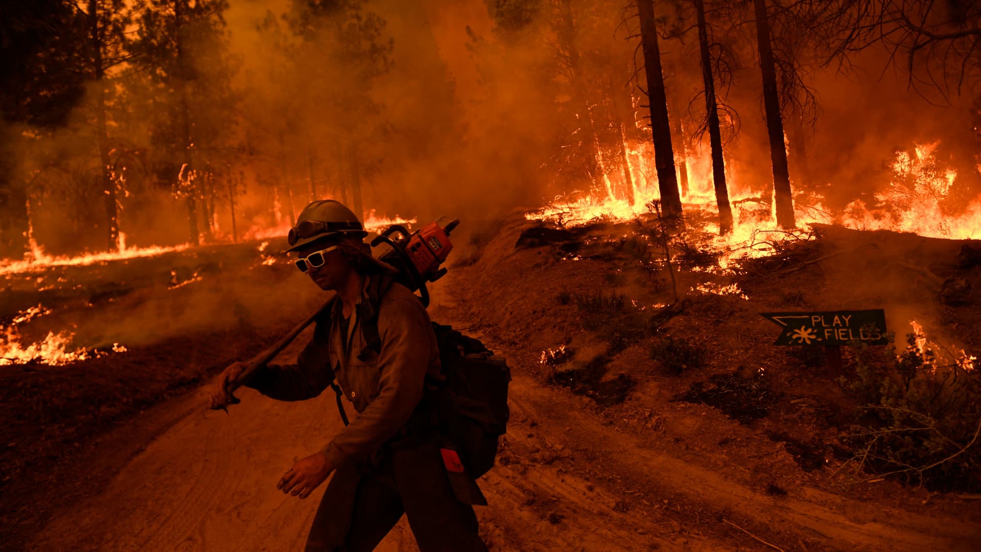 A firefighter with Alaska's Pioneer Peak Interagency Hotshot Crew carries a chain saw as the Windy Fire burns in the Sequoia National Forest near Johnsondale, California, on Sept. 22, 2021.
