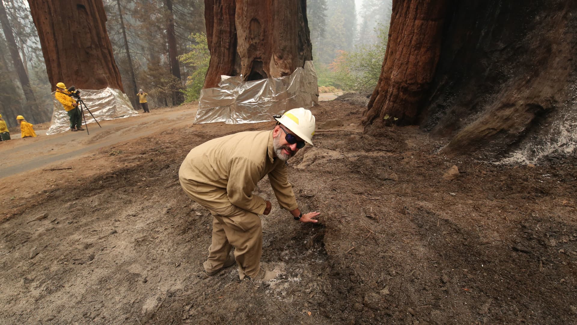 Ed Christopher, deputy fire director at the U.S. Fish and Wildlife Service, checks the residual heat near the Four Guardsmen at Sequoia National Park, Sept. 22, 2021.