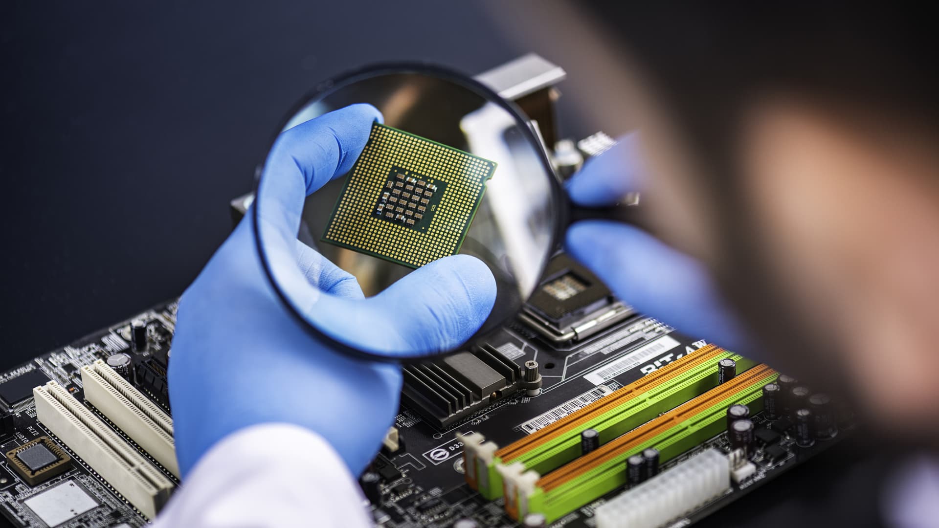 A technologist inspects a computer chip.