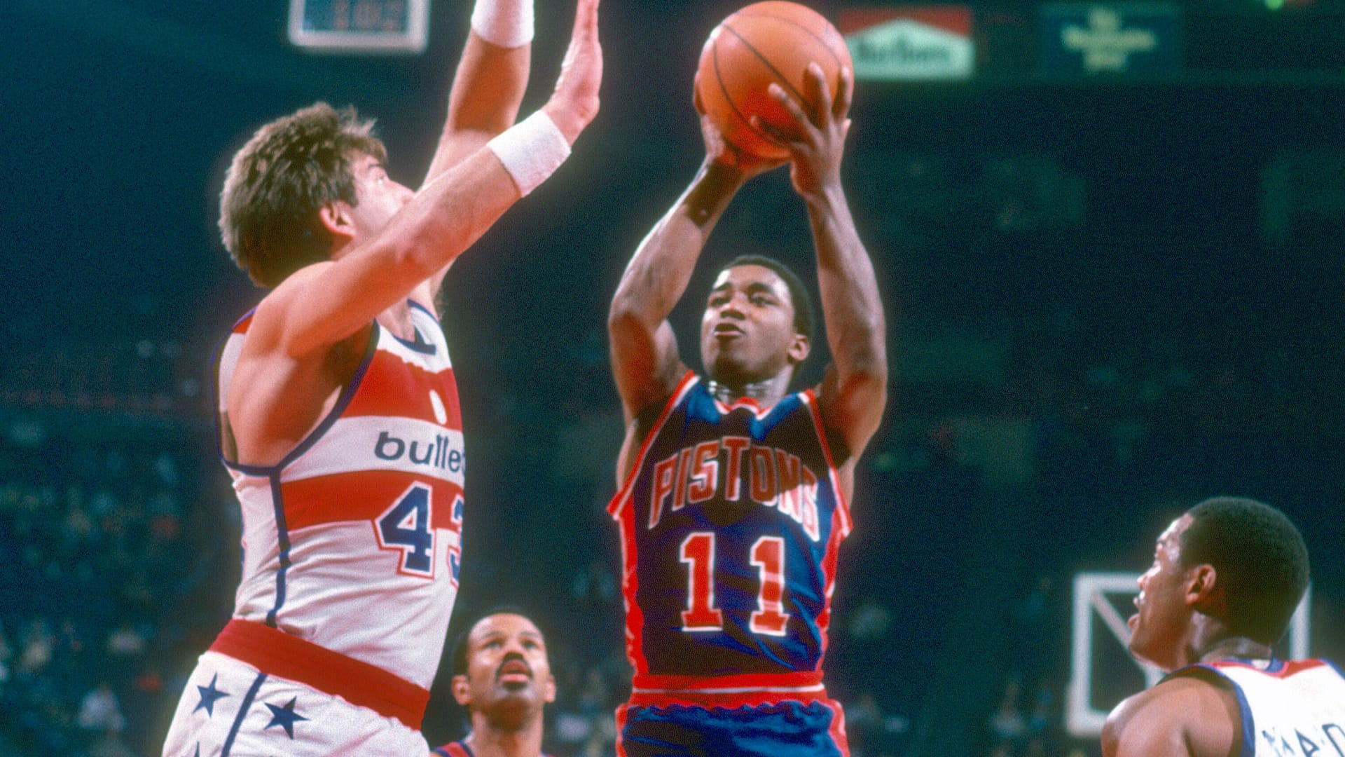 Isiah Thomas #11 of the Detroit Pistons shoots over Jeff Ruland #43 of the Washington Bullets during an NBA basketball game circa 1982 at The Capital Centre in Landover, Maryland.