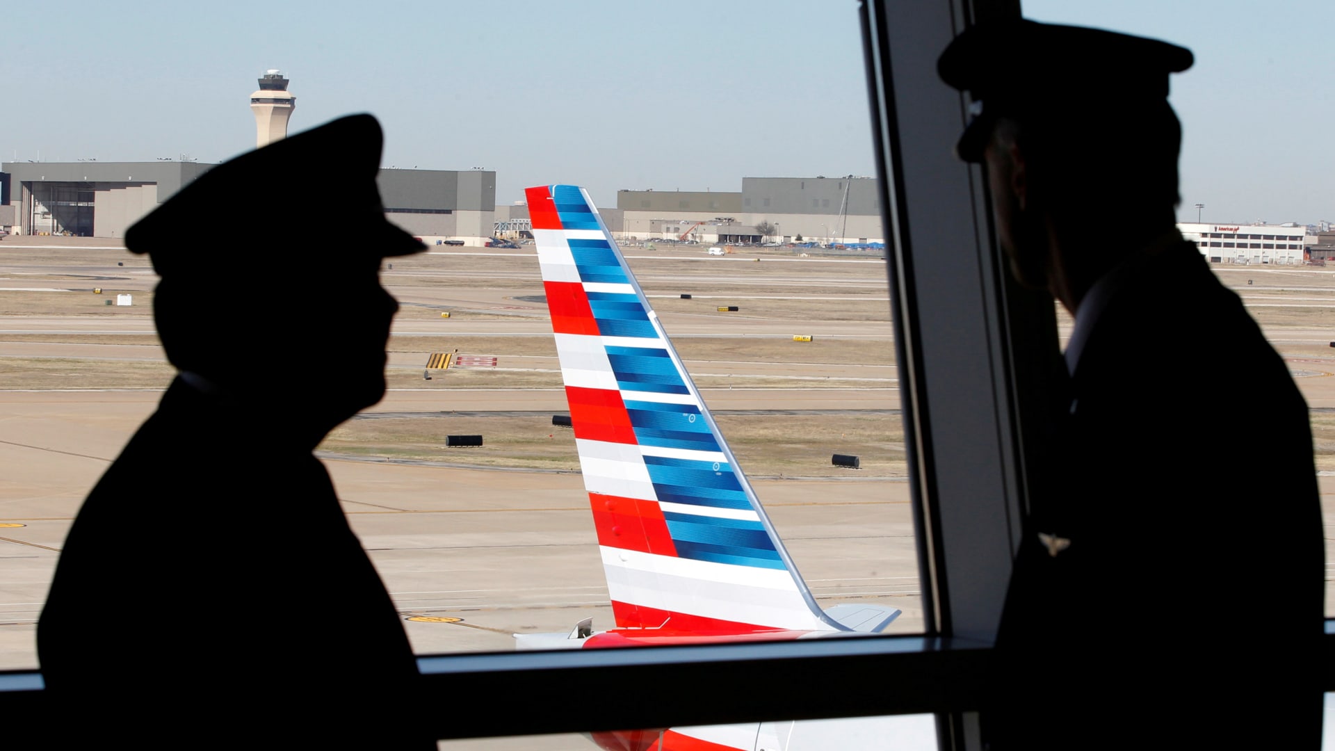 Pilots talk as they look at the tail of an American Airlines aircraft at Dallas-Ft Worth International Airport.
