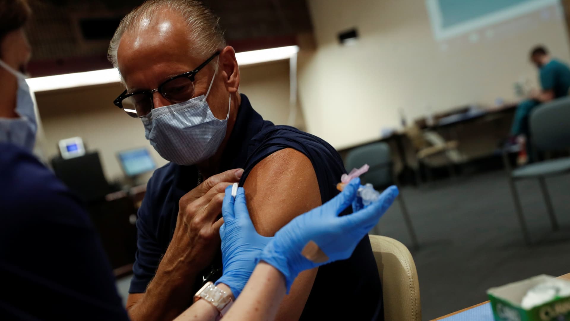 A registered nurse applies a dose of the Moderna COVID-19 vaccine to Sarasota Hospital worker Larry Hammers, 62, at the Sarasota Memorial Hospital in Sarasota, Florida, September 24, 2021.