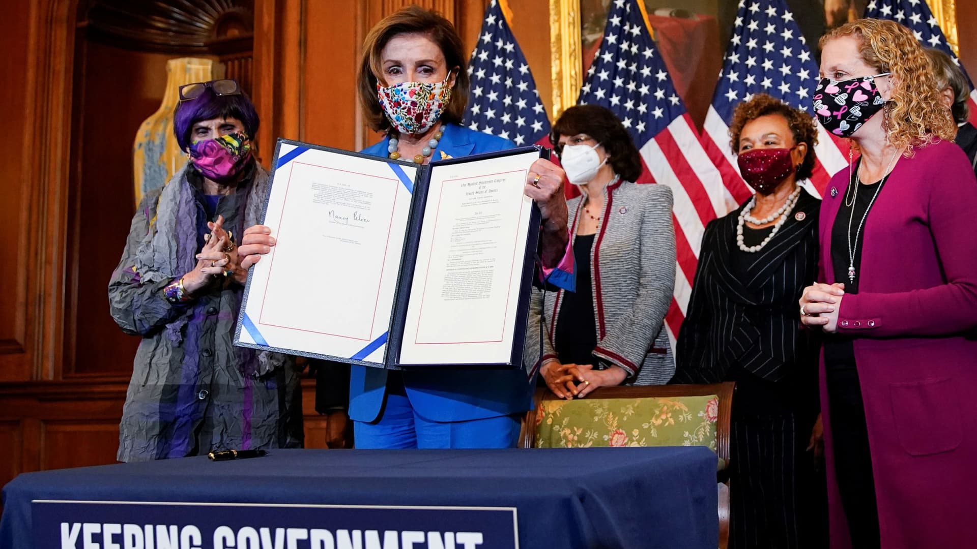 U.S. House Speaker Nancy Pelosi (D-CA) is flanked by members of the House Democratic Caucus as she holds the continuing resolution she signed to avoid a U.S. government shutdown during a bill enrollment ceremony on Capitol Hill in Washington, September 30, 2021.
