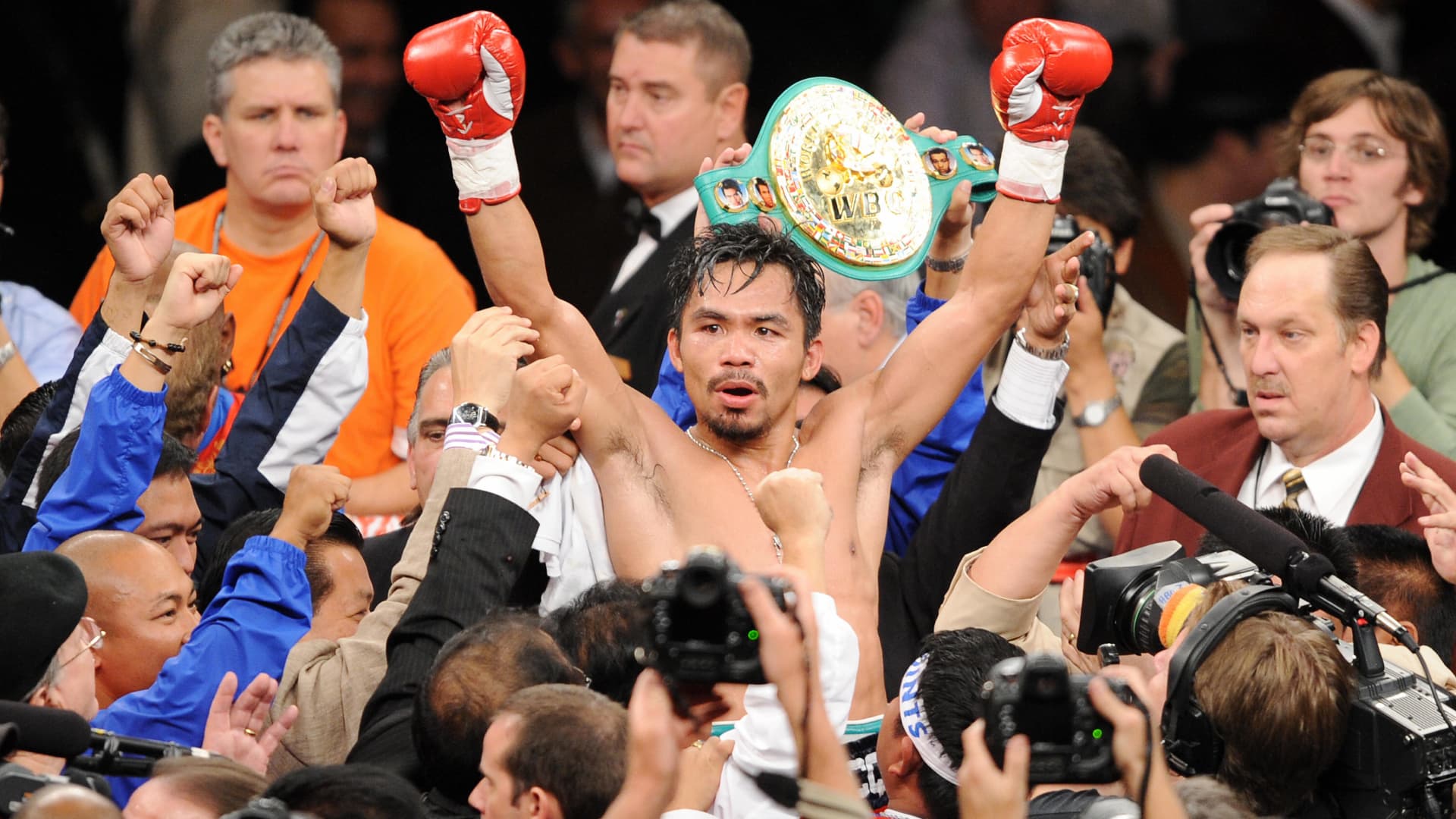 Manny Pacquiao of the Philippines (C) celebrates after defeating Oscar de la Hoya of the U.S. during their welterweights showdown at the MGM Grand Garden Arena in Las Vegas, Nevada, on December 6, 2008.