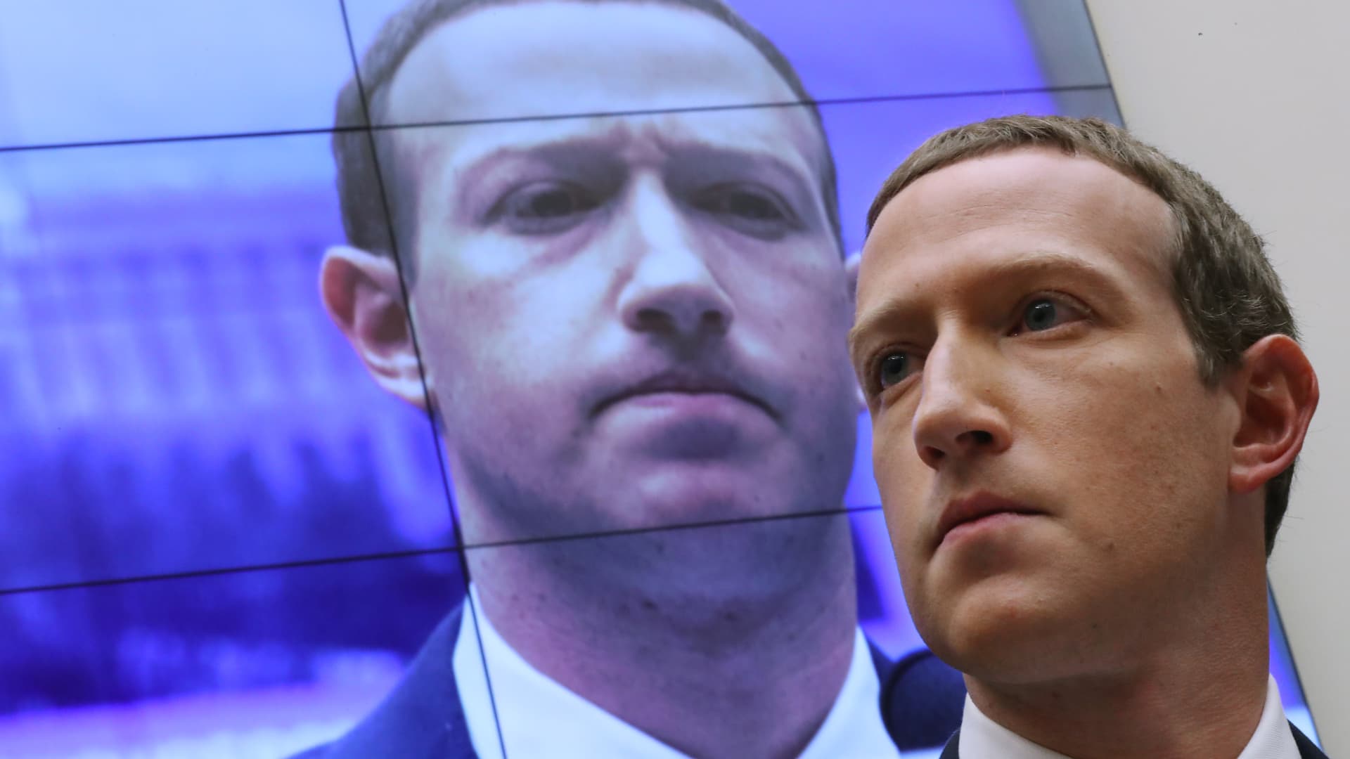 With an image of himself on a screen in the background, Facebook co-founder and CEO Mark Zuckerberg testifies before the House Financial Services Committee in the Rayburn House Office Building on Capitol Hill October 23, 2019 in Washington, DC.