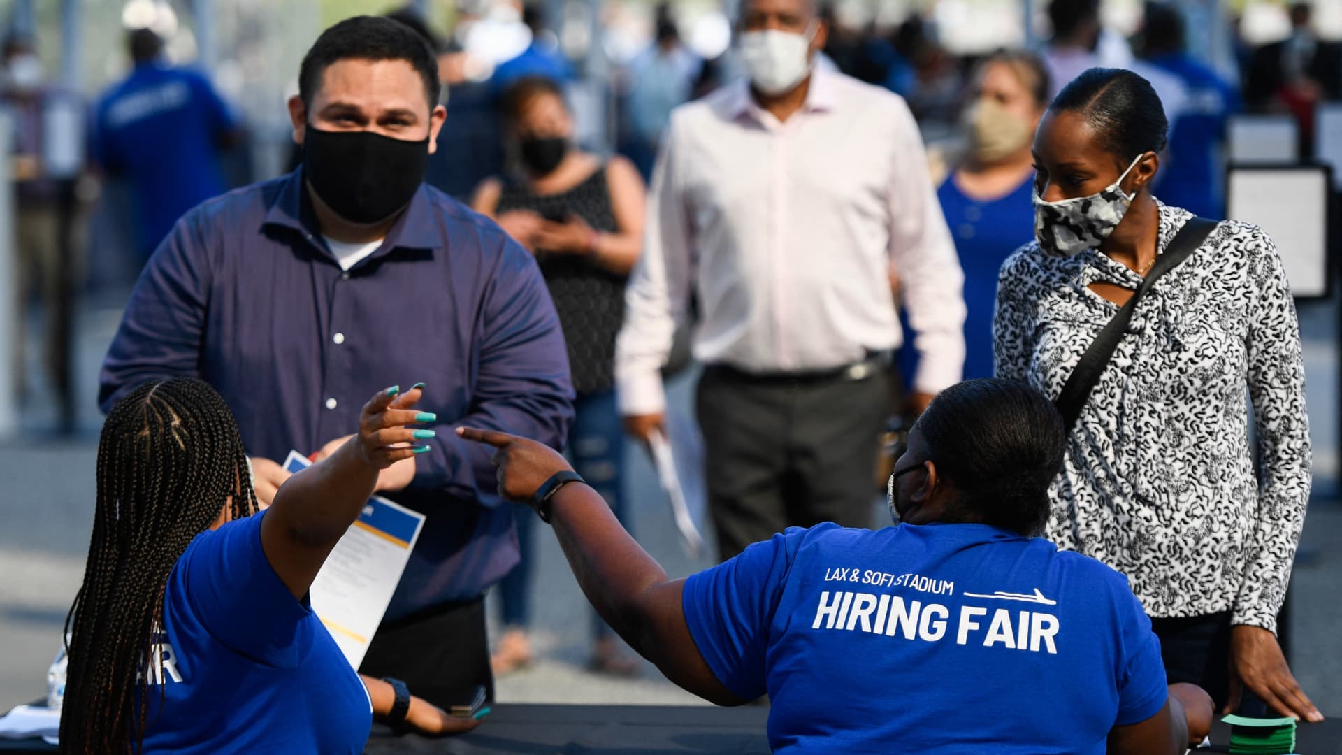 People receive information as they attend a job fair at SoFi Stadium on Sept. 9, 2021, in Inglewood, California.