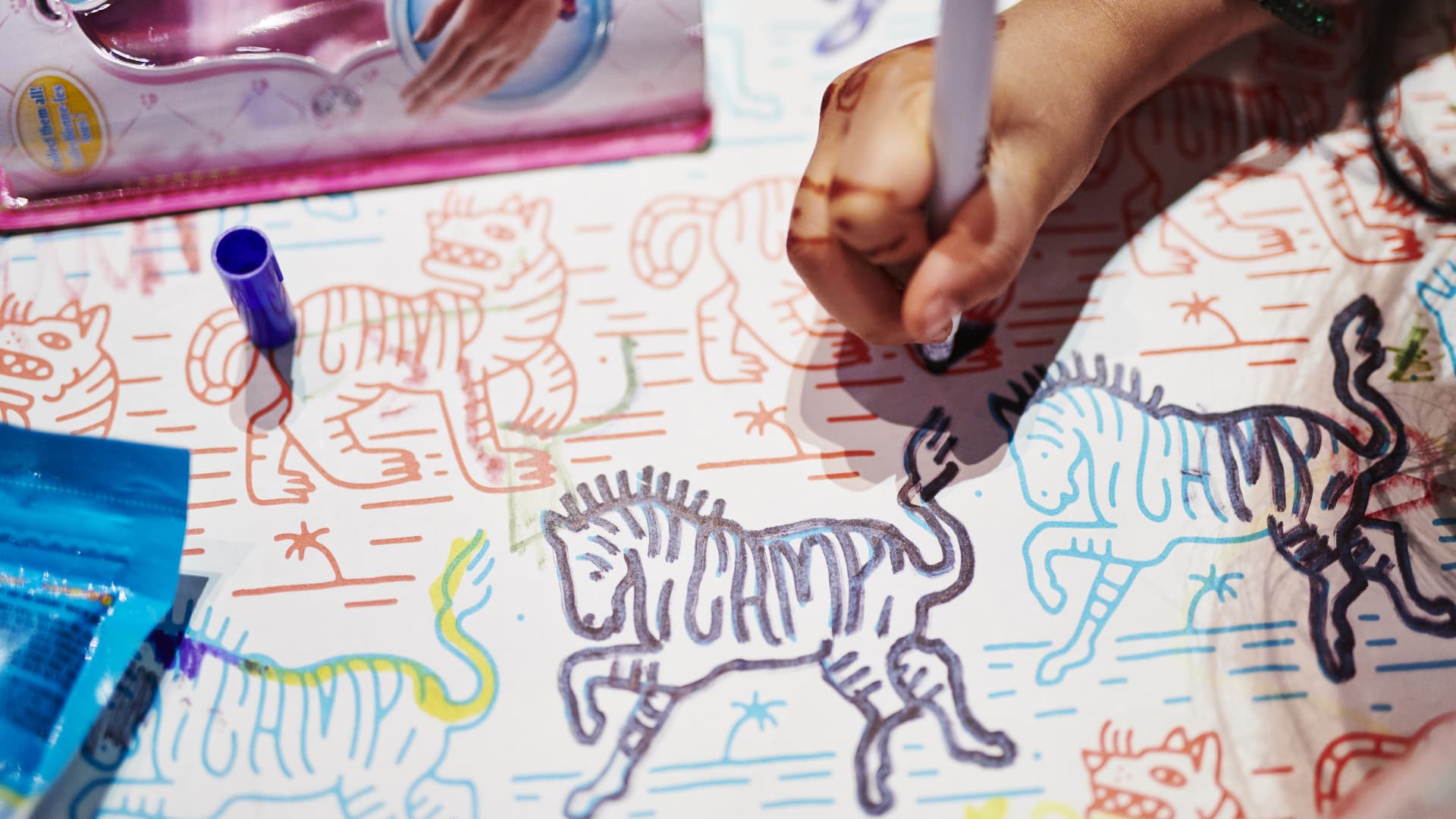 A child draws with markers on a pad at the Camp retail location in New York, June 4, 2019.