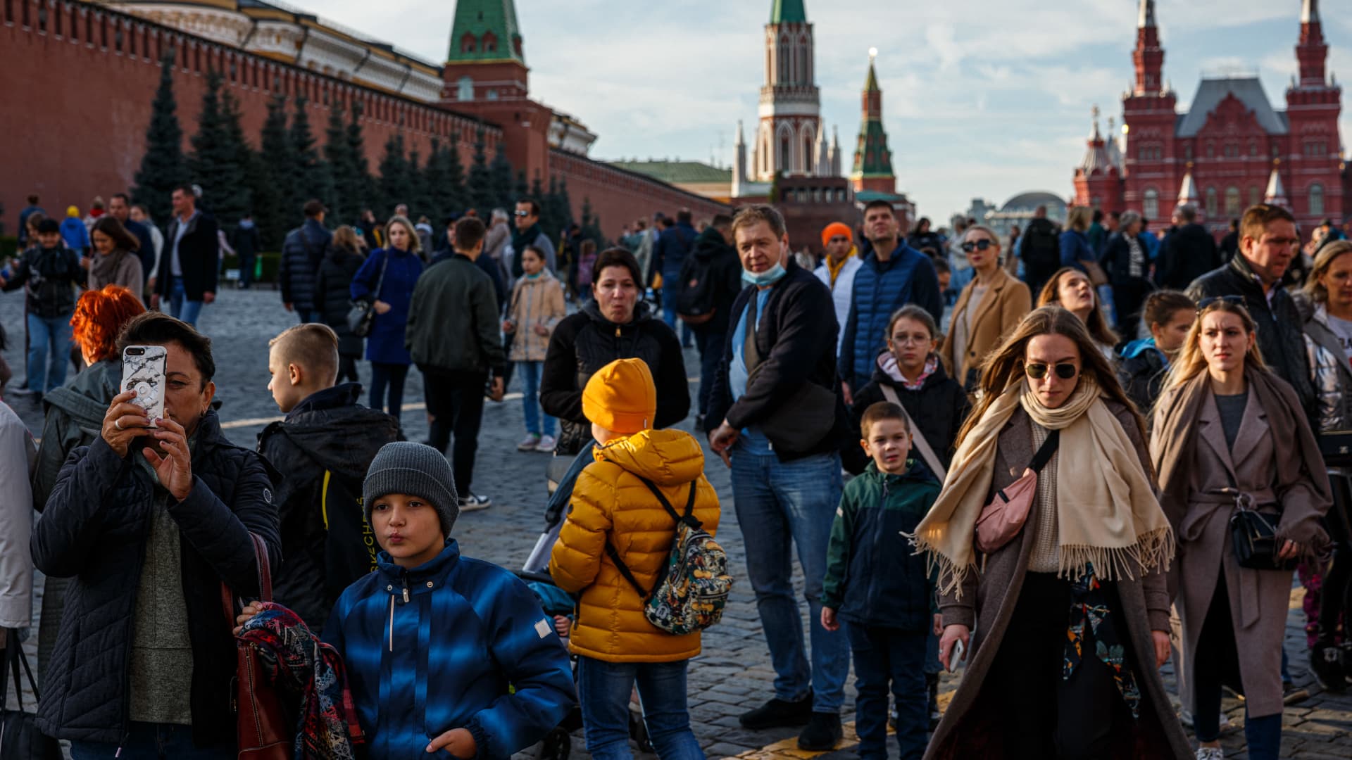 People walk through the Red Square in a sunny autumn day in Moscow on October 9, 2021.