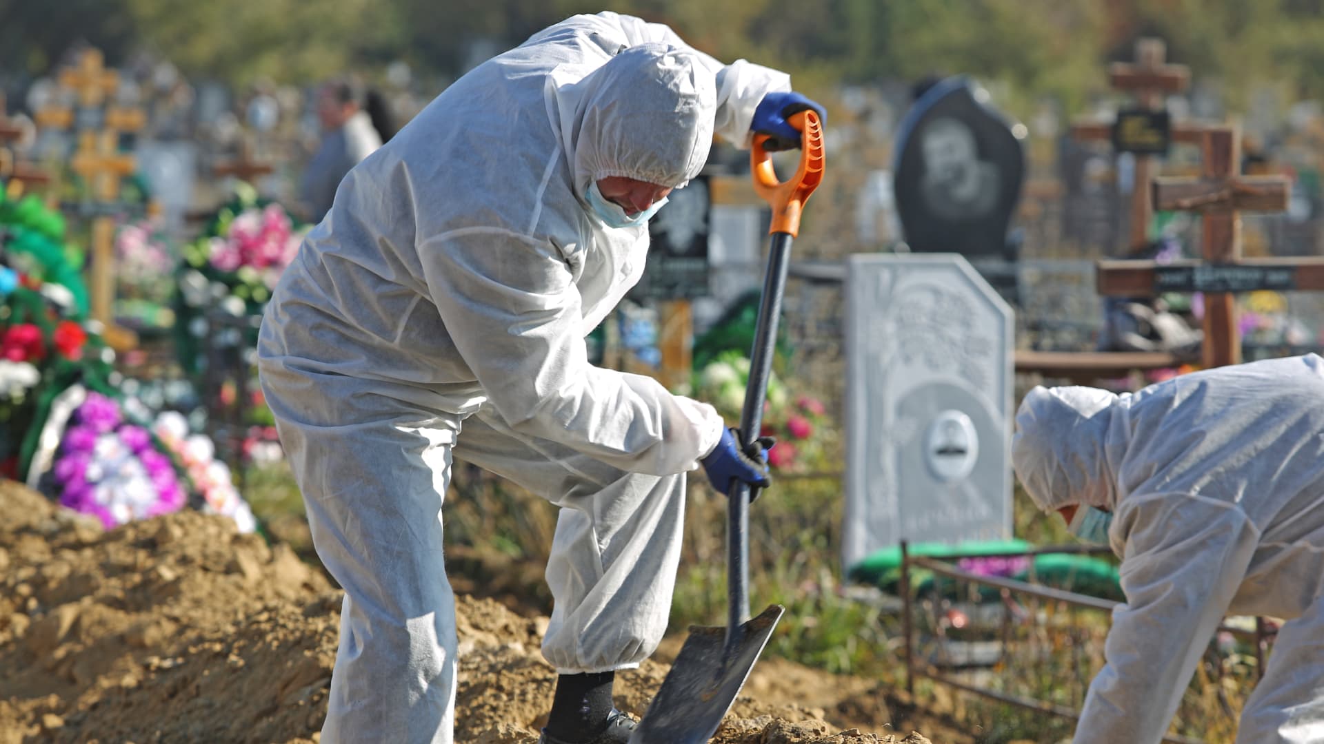 Cemetery workers in protective gear bury people who died of causes related to Covid-19 at Novo-Yuzhnoye Cemetery in Omsk, Russia.