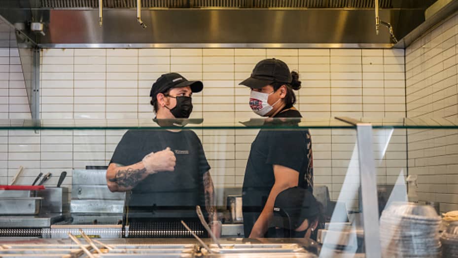 Prices at Chipotle Mexican Grill are up roughly 4% to cover the cost of raising the chain's minimum wage to $15 an hour. Pictured, Chipotle employees in Houston.