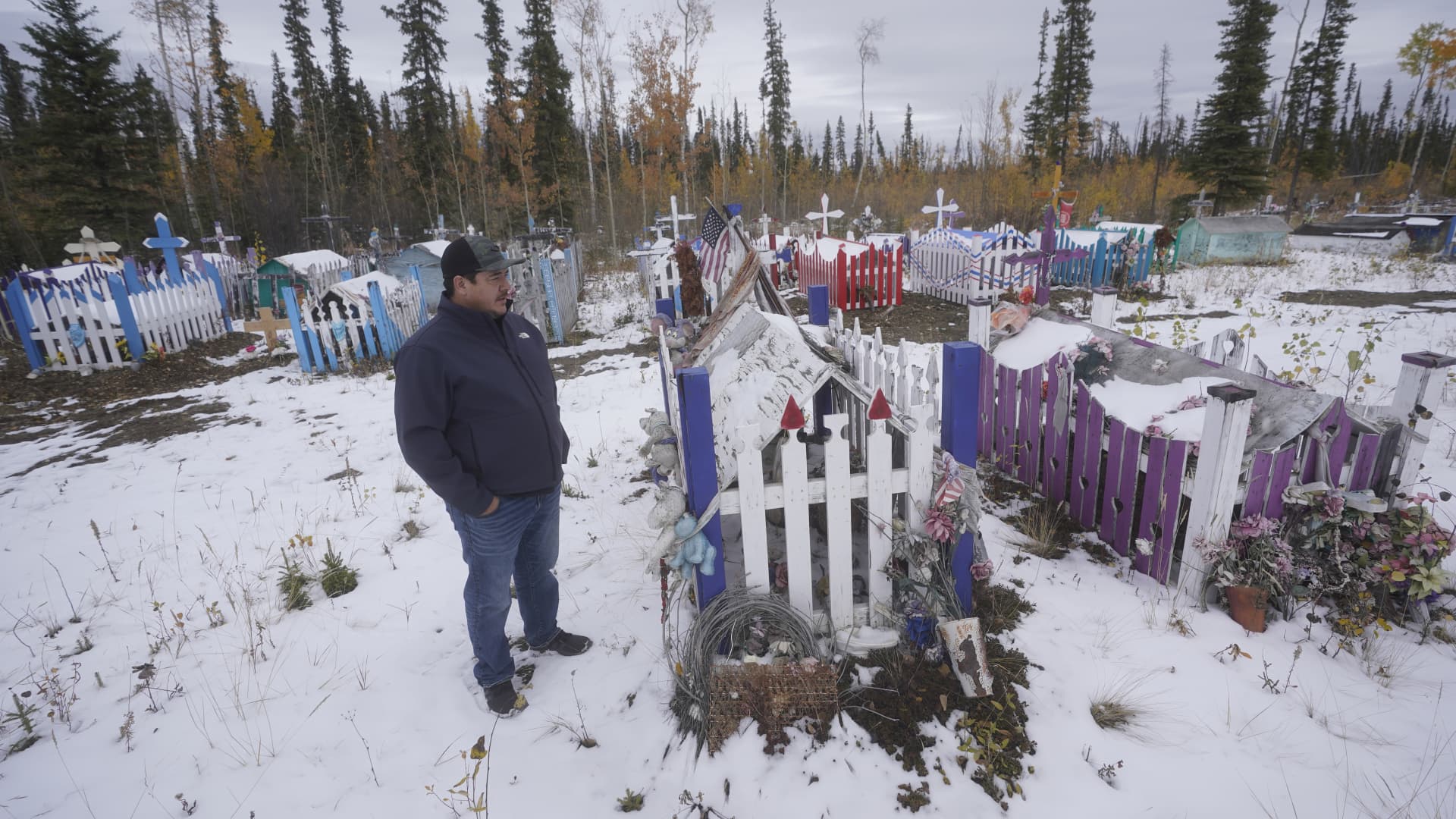 Herbie Demit, Tanacross Village Council president, walks through a cemetery Thursday, Sept. 23, 2021, in Tanacross, Alaska. Alaska is experiencing one of the sharpest rises in COVID-19 cases in the country, coupled with a limited statewide healthcare system that is almost entirely reliant on Anchorage hospitals.
