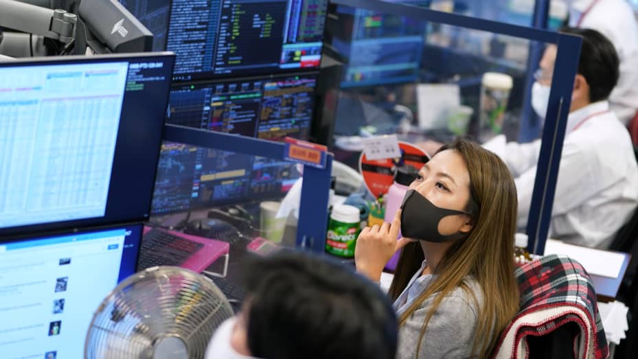 Employees wearing protective masks work in the trading room at the Daiwa Securities Group Inc. headquarters in Tokyo, Japan, on Thursday, Oct. 14, 2021.